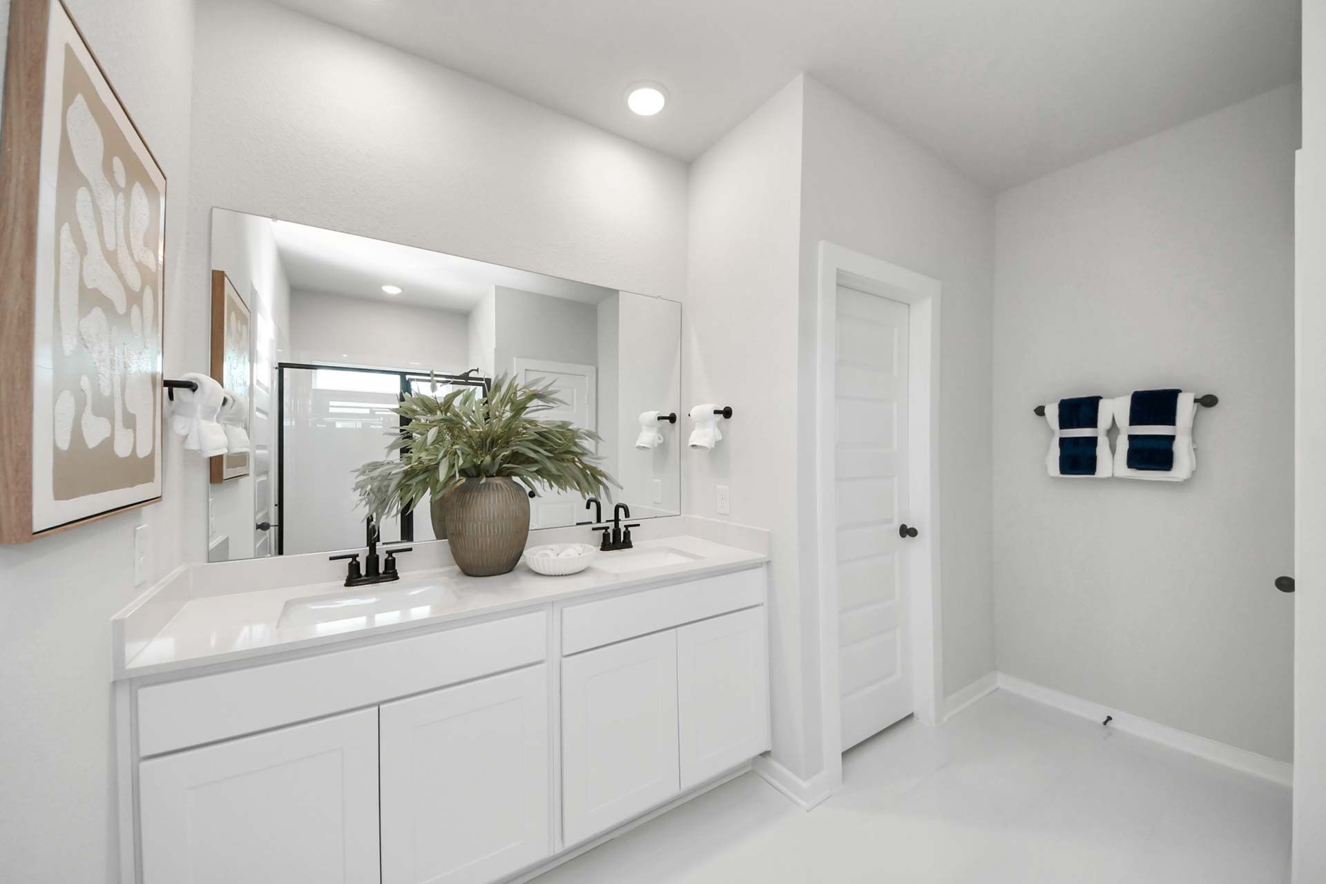 Modern bathroom with double vanity and white countertops at Enclave at Newport in Crosby, Texas by Davidson Homes