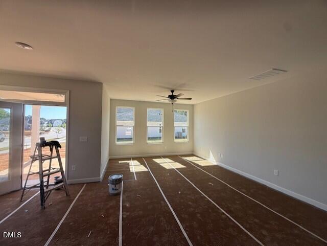 Sunlit great room with sliding glass doors to patio, triple windows, ceiling fan in Davidson Homes The Ash B, Zebulon, NC