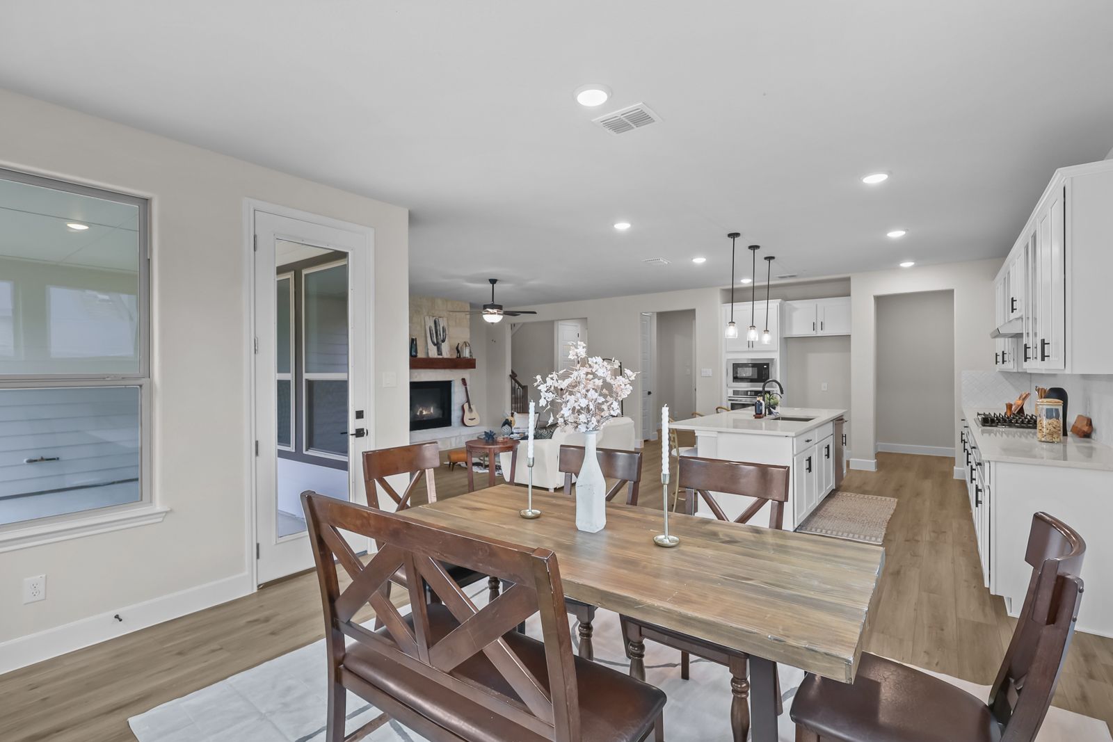 Open-concept dining area and kitchen in The Belmont J floor plan, featuring a large island and spacious living room.