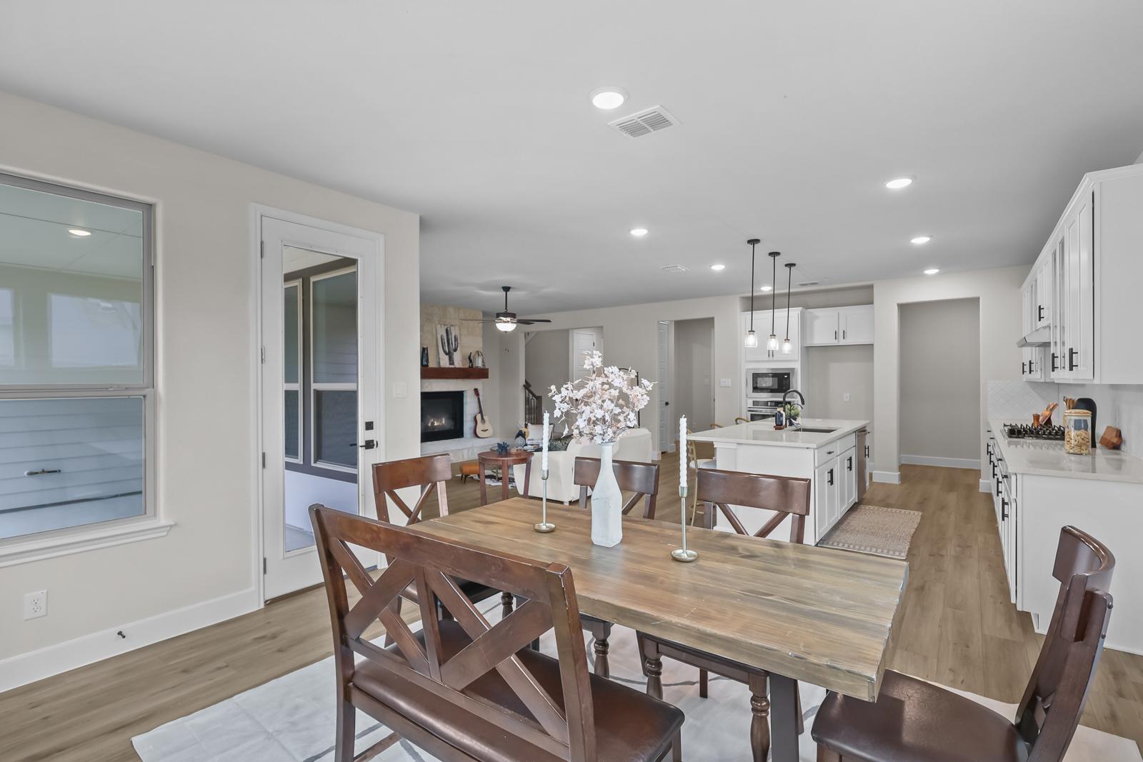 Open-concept dining area and kitchen in The Belmont J floor plan, featuring a large island and spacious living room.