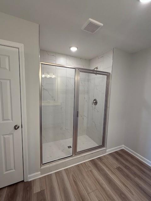 Elegant master bathroom with glass shower enclosure, subway tile, and light wood flooring in Davidson Homes The Durham D, Cumming GA