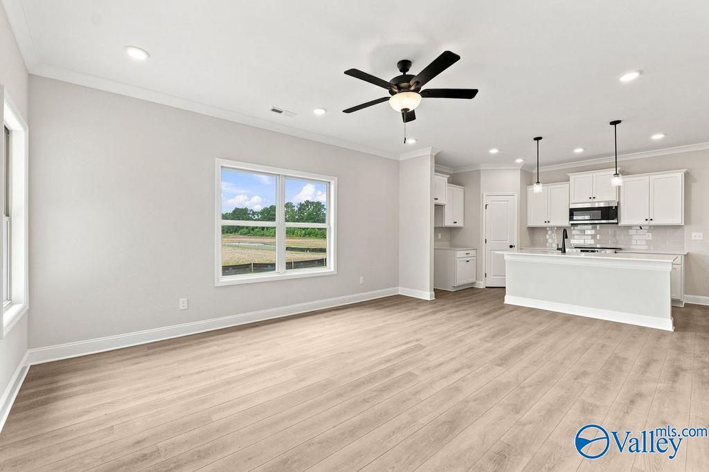 Open-concept living room and modern kitchen in The Camilla B floor plan at The Retreat at Cain Park, Hartselle, Alabama.