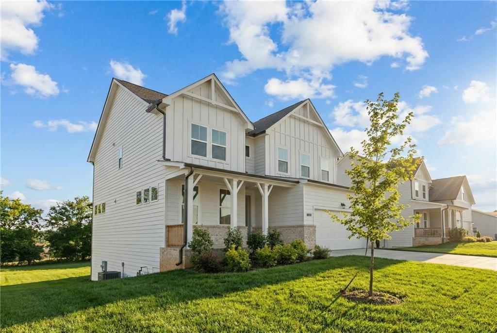 White two-story Davidson Homes Willow B with gabled roof, covered porch, two-car garage, and landscaped yard in Wehunt Meadows, Hoschton, GA