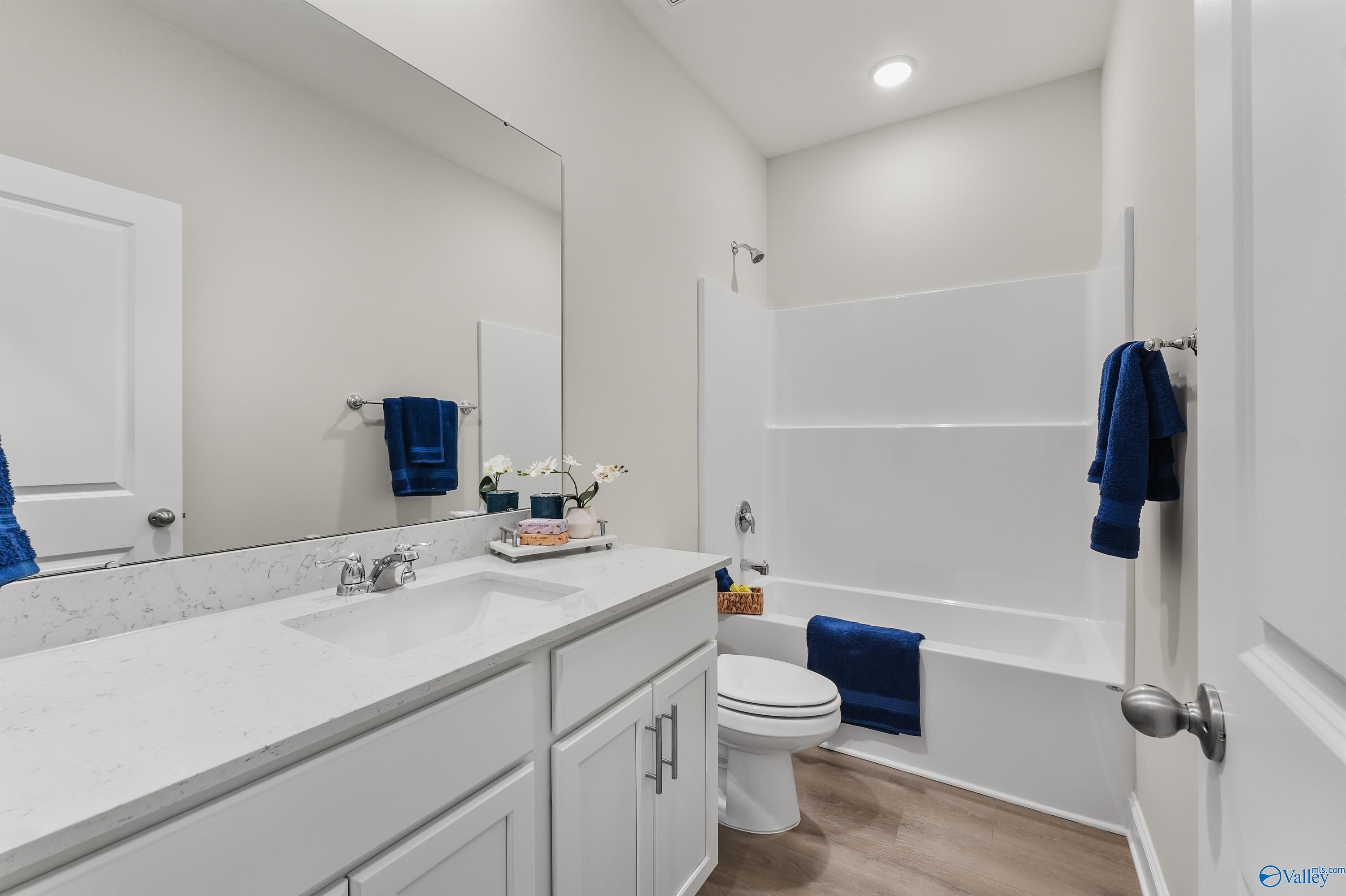 Modern bathroom with soaking tub, walk-in shower, quartz vanity, and blue accents in Davidson Homes The Asheville C, Huntsville, AL