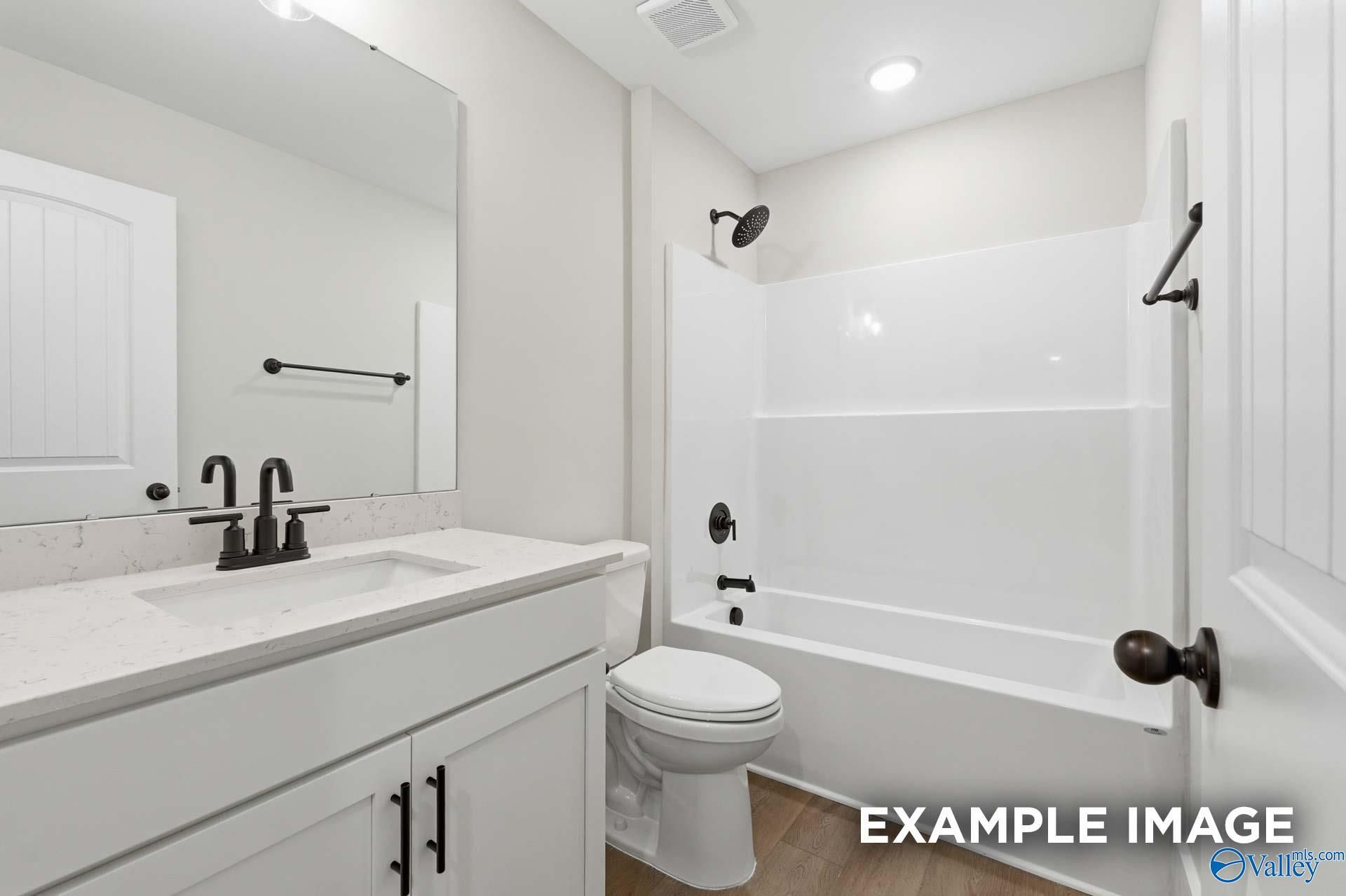Modern bathroom with white vanity, quartz countertop, and black fixtures in The Rockford floor plan, Briercreek, Alabama.