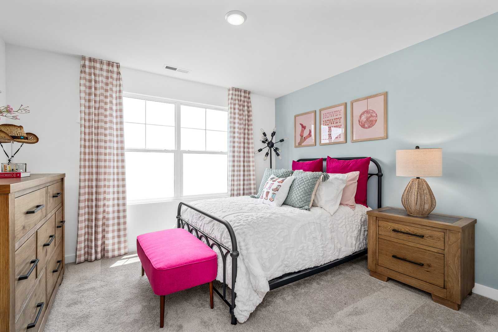 Cozy bedroom at Calista Farms in White House TN with light blue walls, tufted bed, wooden dresser, pink bench, and large window