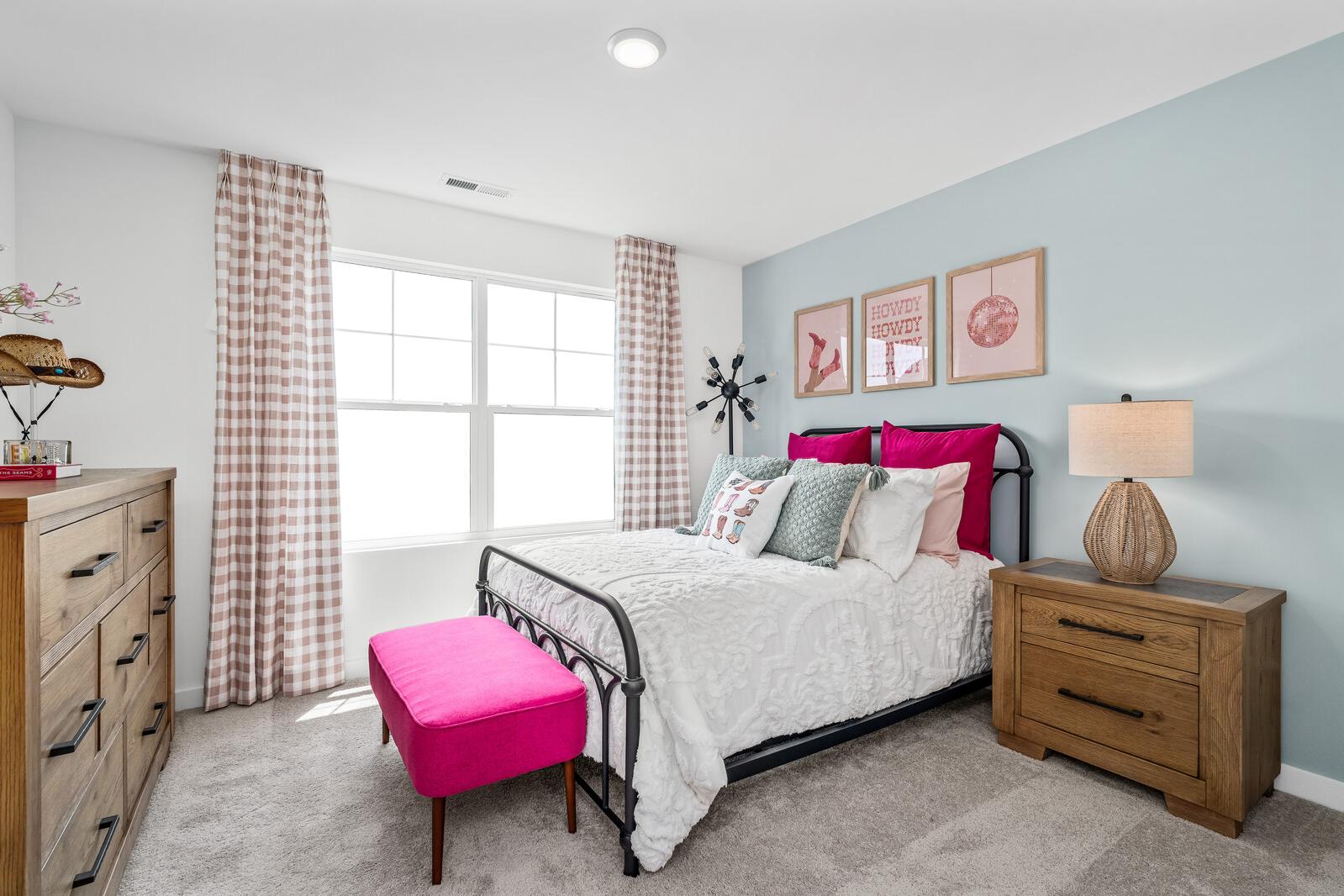 Cozy bedroom at Calista Farms in White House TN with light blue walls, tufted bed, wooden dresser, pink bench, and large window