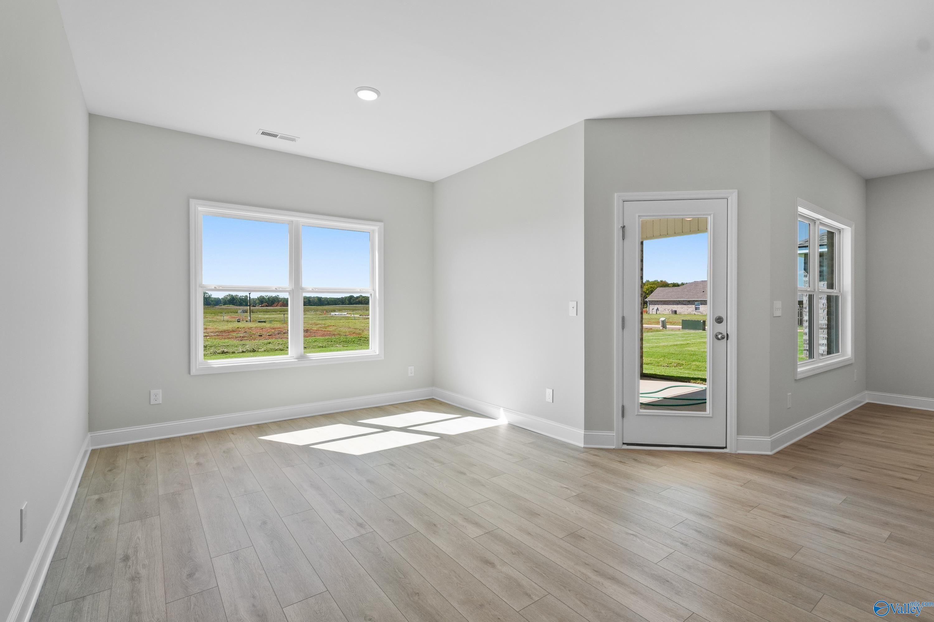 Bright bedroom with large windows and glass door overlooking green fields in Davidson Homes The Everett, Hazel Green, AL