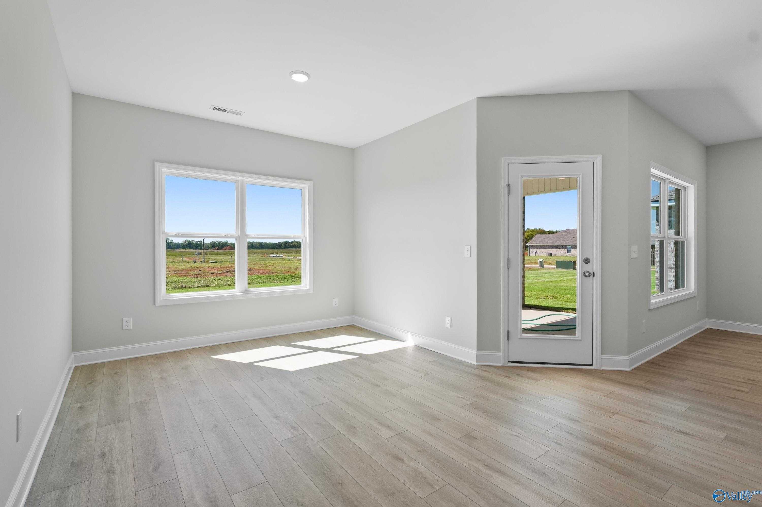 Bright bedroom with large windows and glass door overlooking green fields in Davidson Homes The Everett, Hazel Green, AL