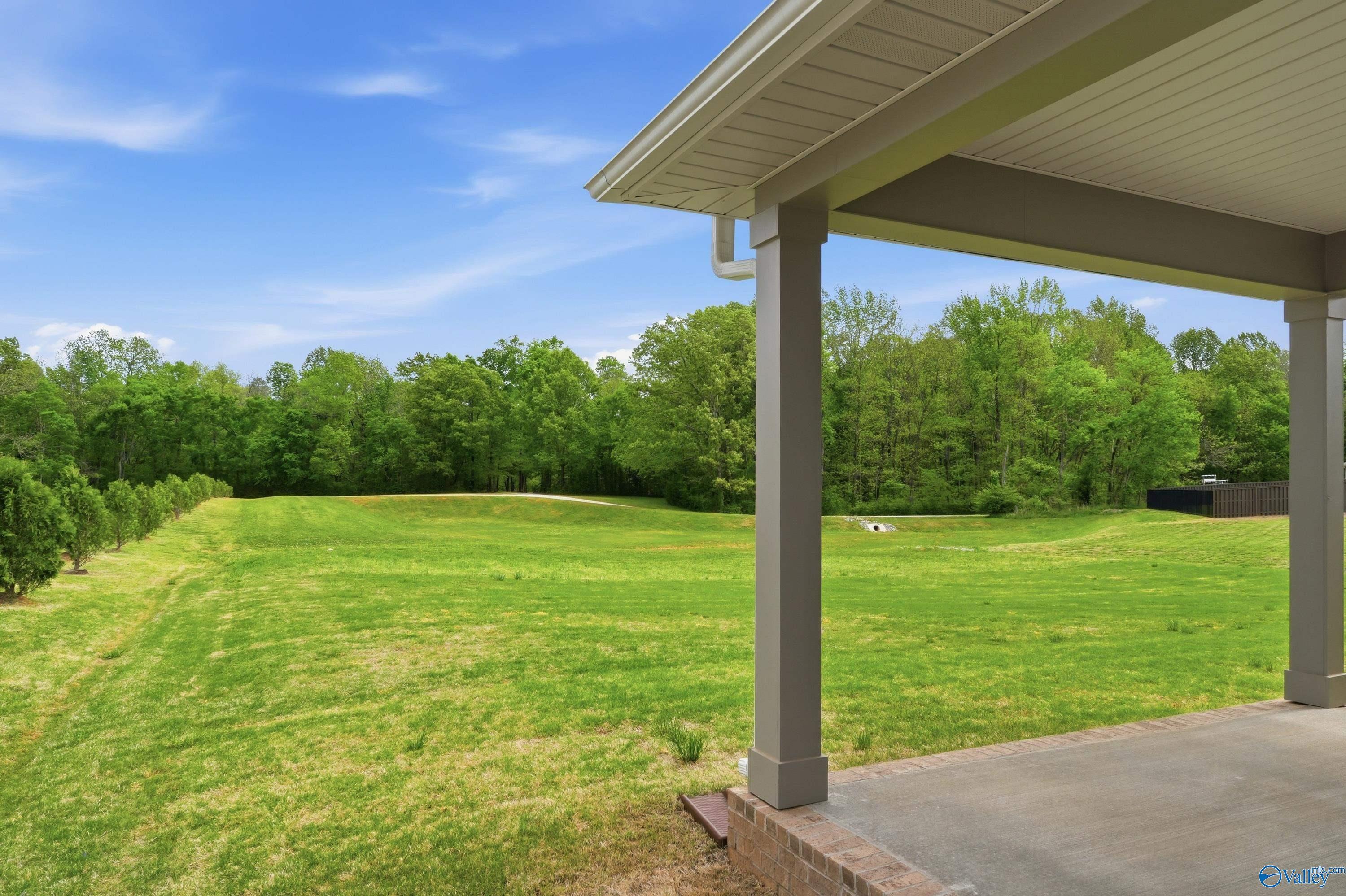 Covered back patio overlooking expansive green backyard and wooded trees in Davidson Homes The Dorado, Riverton Preserve, Huntsville, Alabama