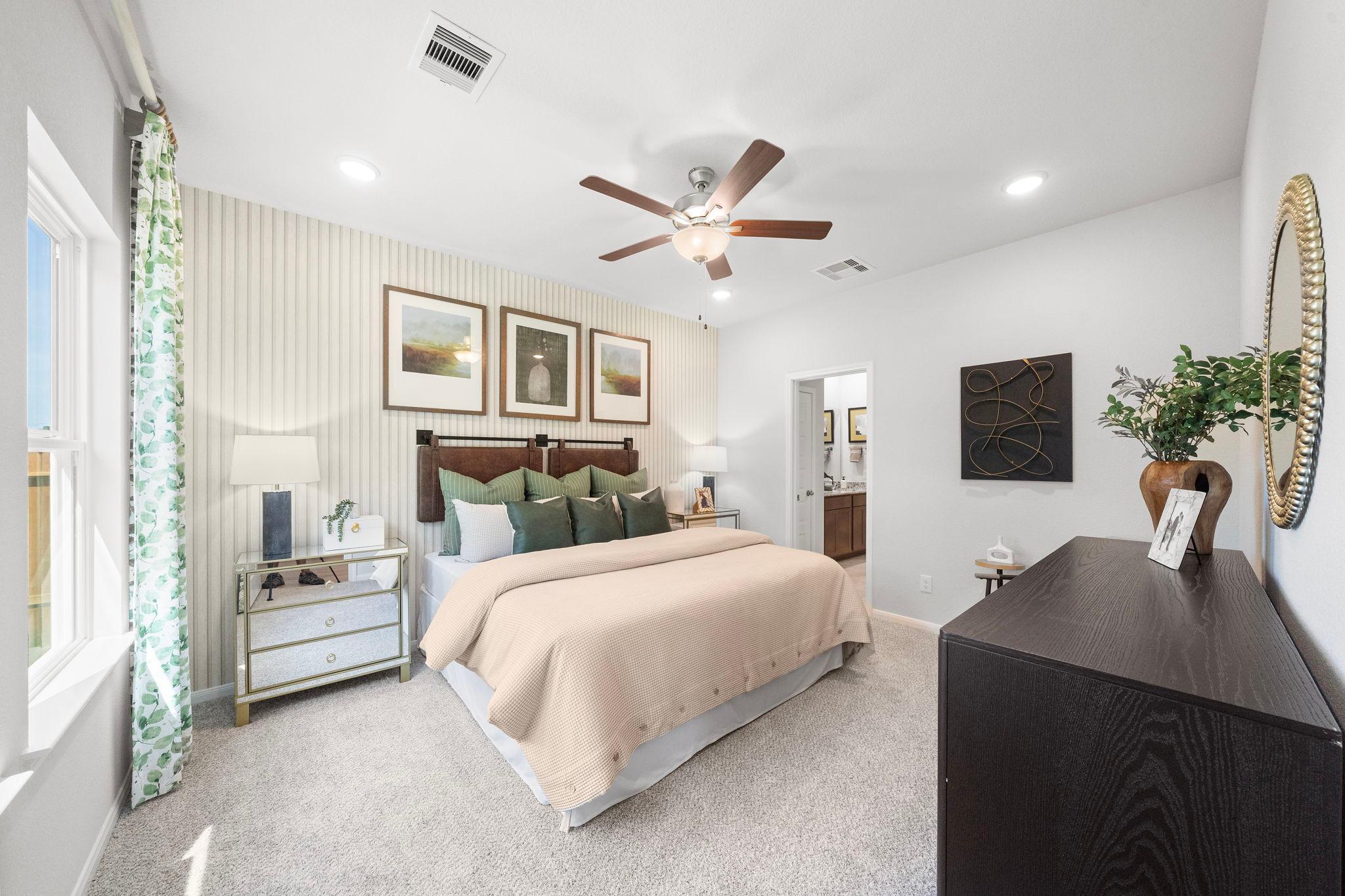 Spacious primary bedroom at Caney Creek Place in Conroe Texas with king bed, ceiling fan, and neutral decor