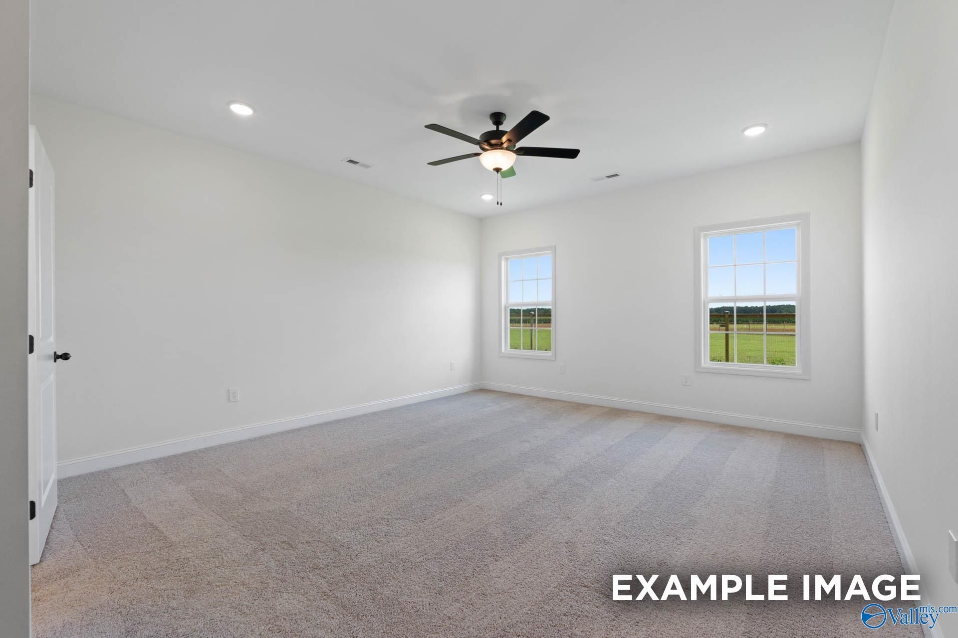 Spacious carpeted bedroom with ceiling fan and natural light in The Rockford B floor plan, Briercreek, Meridianville.