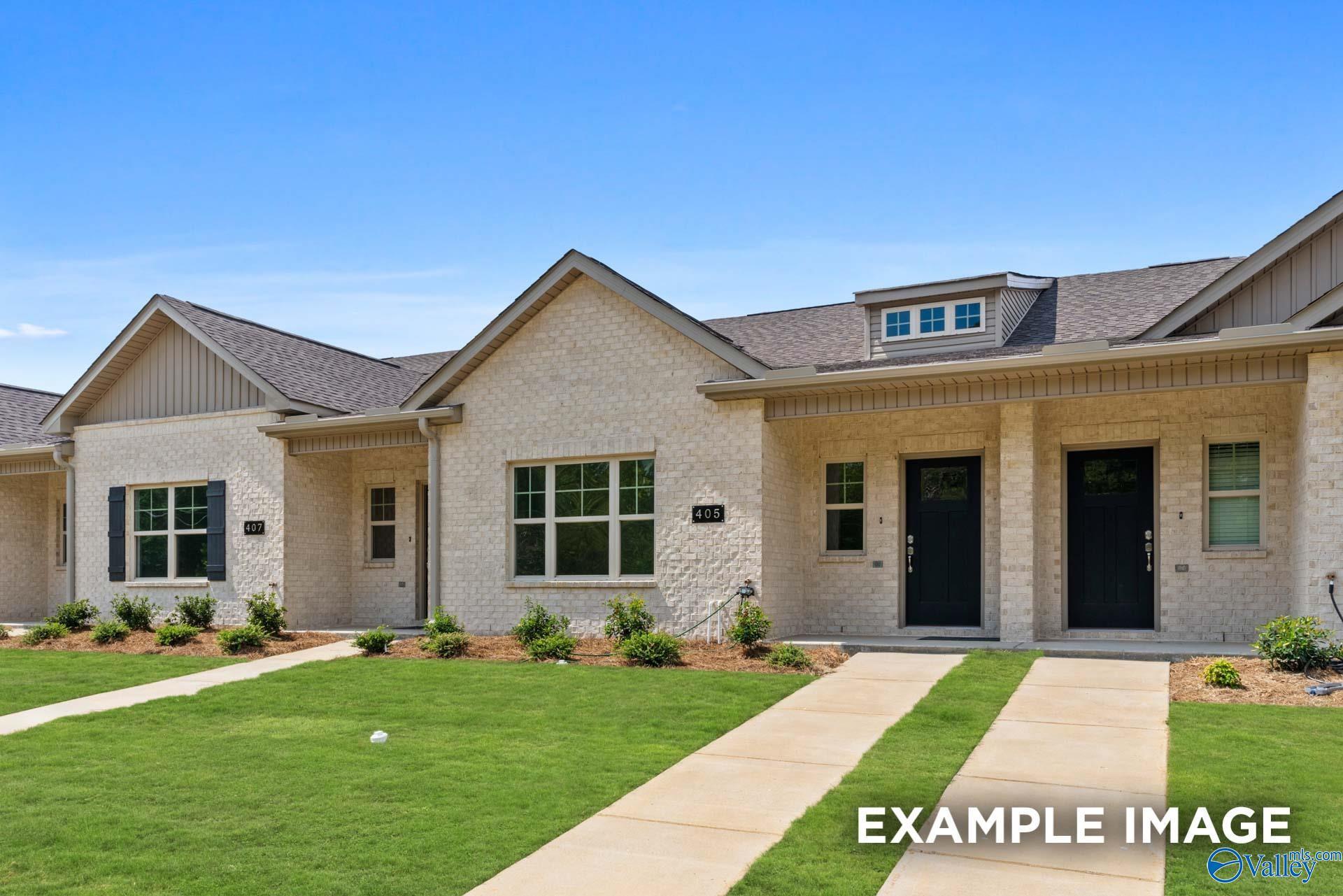 Modern beige brick single-story homes with gabled roofs, black doors, and landscaped lawns in The Retreat at Cain Park, Hartselle, Alabama