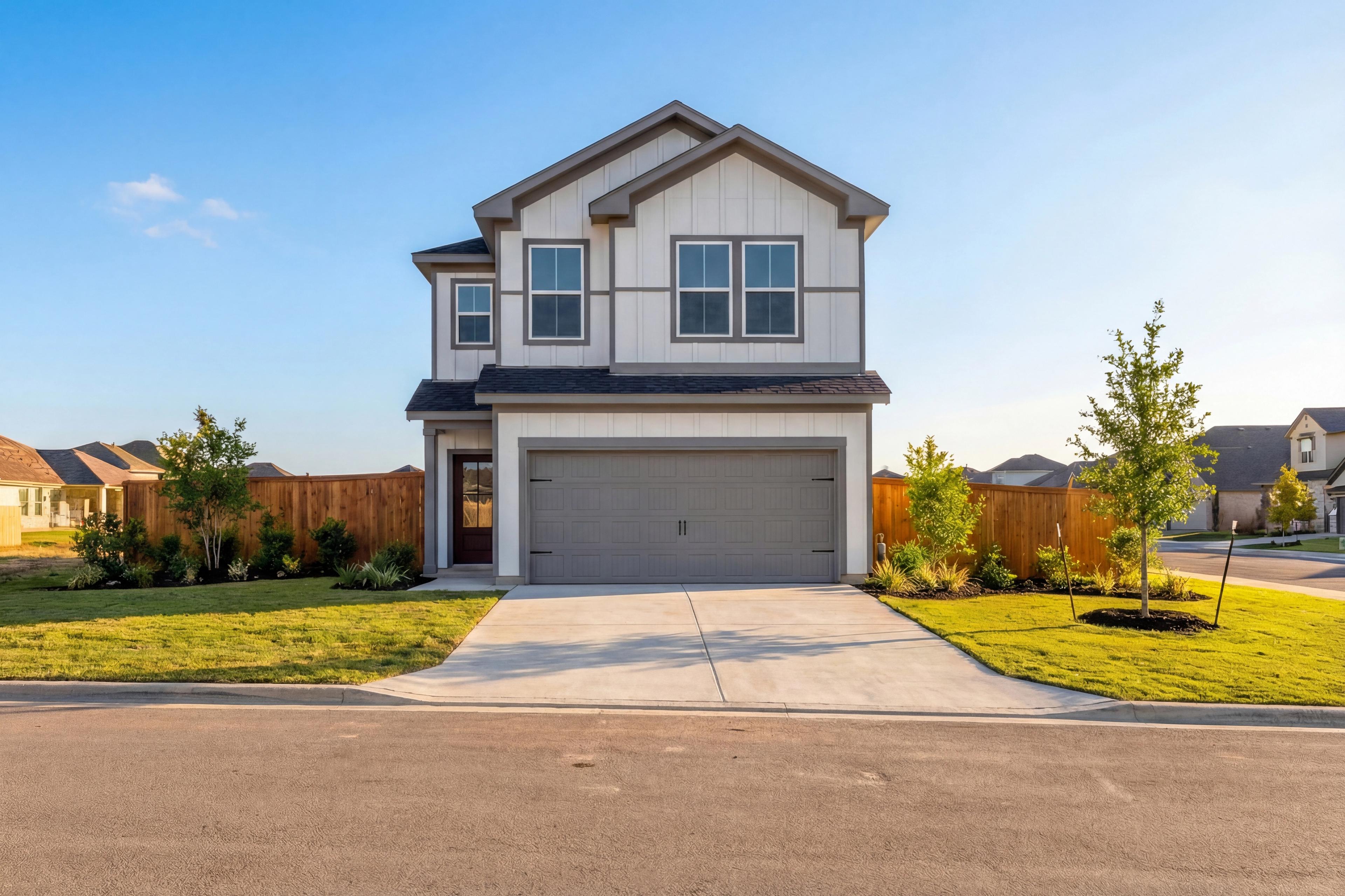 Two-story The Gillian C elevation featuring white shiplap siding, dark trim, two-car garage, and landscaped yard in San Antonio