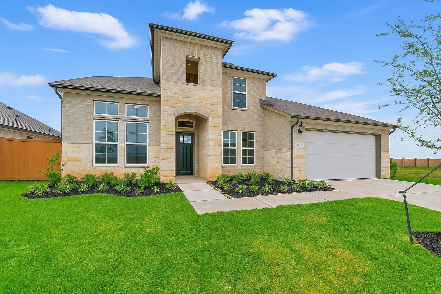 Two-story beige brick home with arched windows, 4-car garage, and lush front yard in Lago Mar, Texas City, Texas