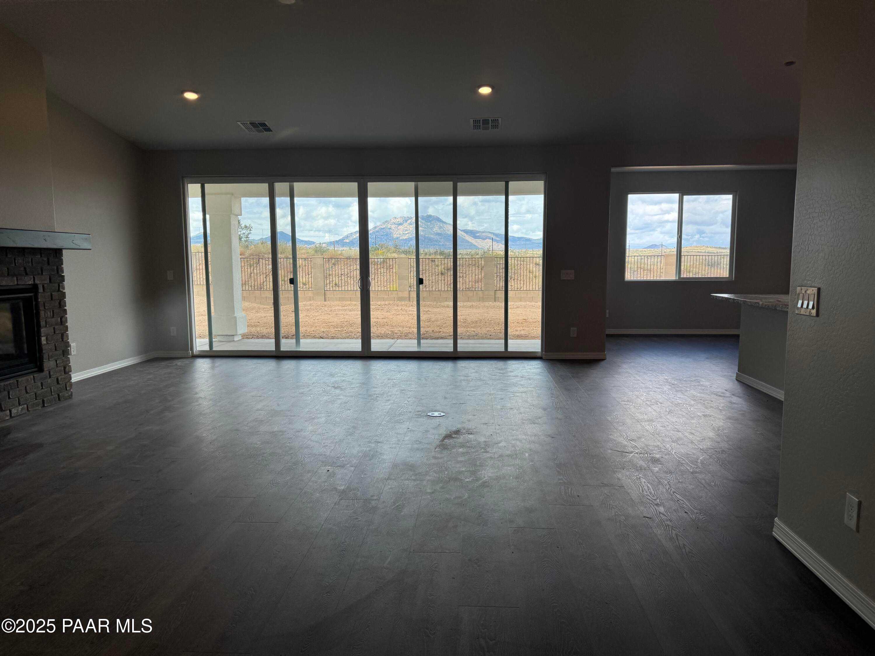 Spacious great room with stone fireplace, sliding doors to desert mountain views in Davidson Homes The Monarch E, Prescott AZ