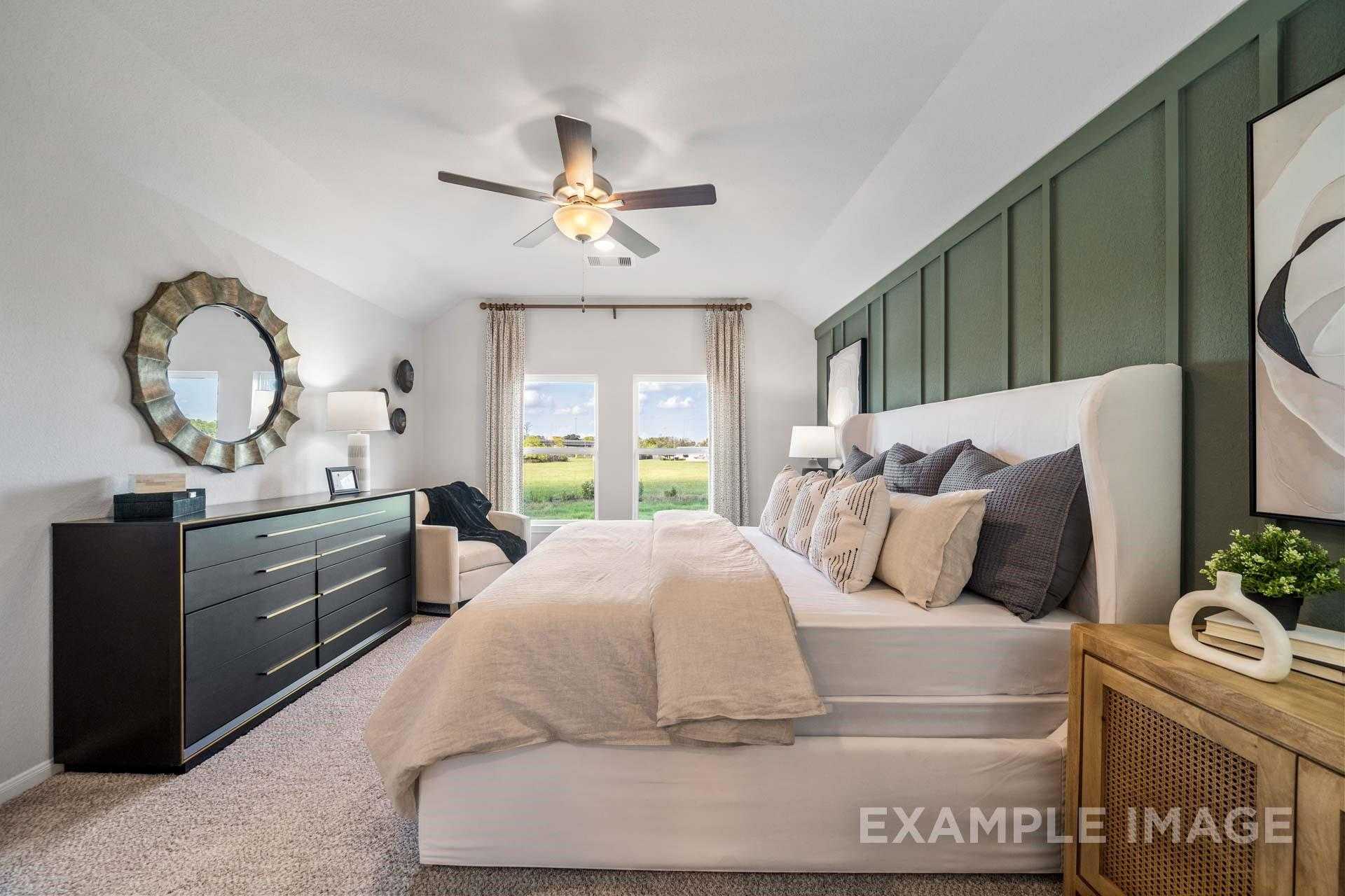 Elegant master bedroom with white upholstered bed, green shiplap wall, ceiling fan in Davidson Homes The Acadia A, Lago Mar, Texas