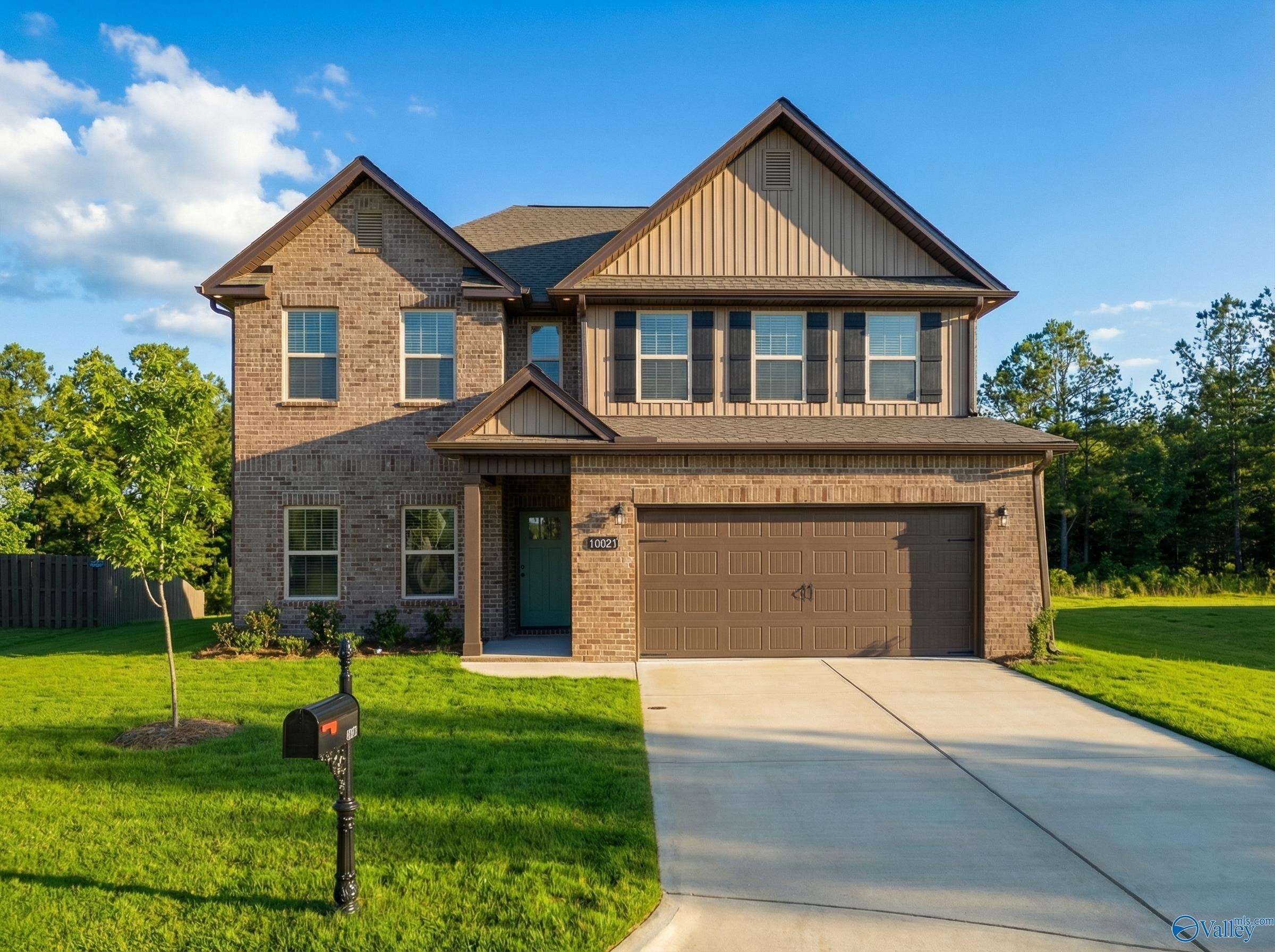 Two-story brick home with 2-car garage, driveway, and lush green yard in Ricketts Farm, Athens, Alabama - Davidson Homes The Shelby A