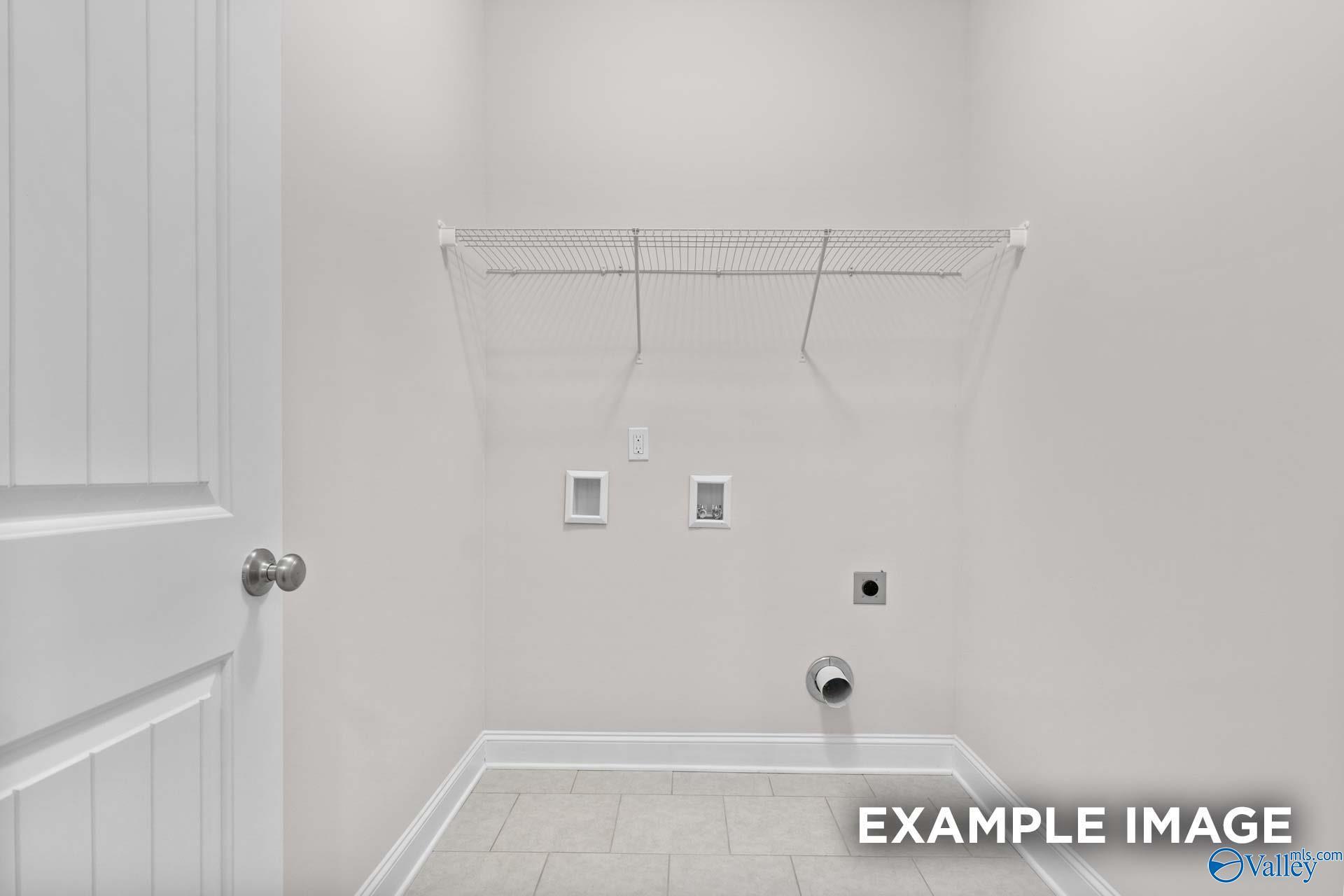 Bright laundry room with wire shelving, washer/dryer hookups in Davidson Homes The Montgomery C, Creekside, Harvest, Alabama