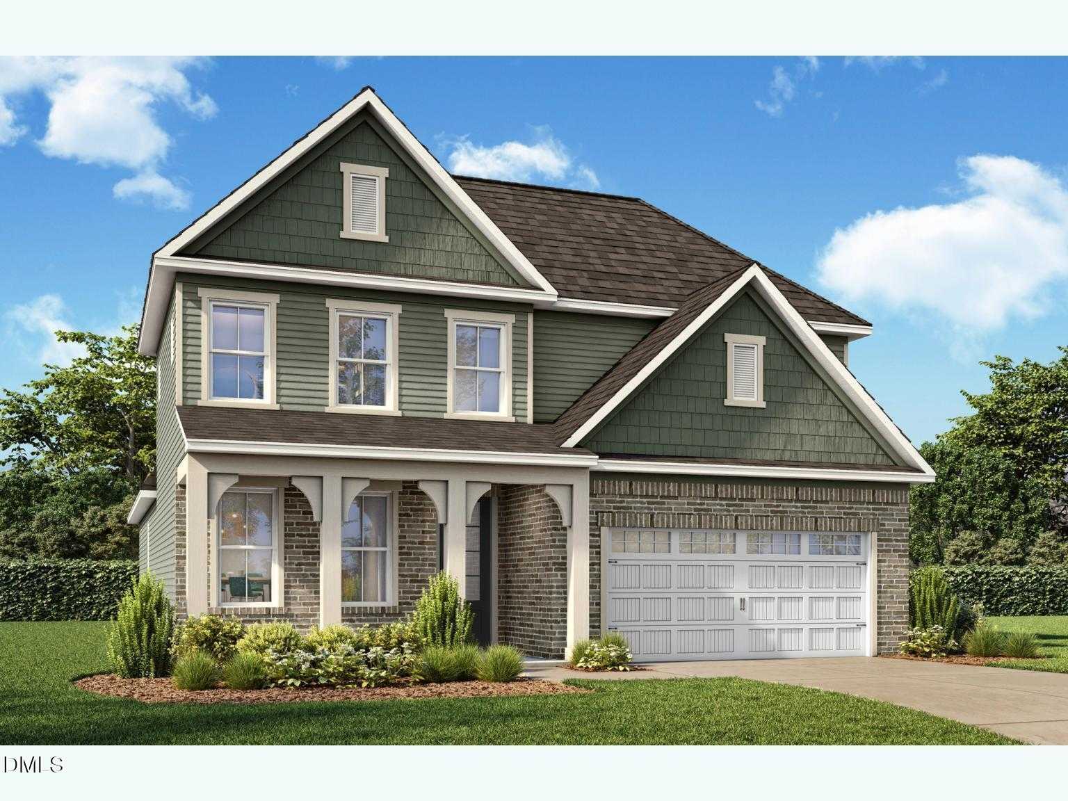 Two-story Ashport L home by Davidson Homes: green siding, brick accents, 2-car garage, arched front porch in Sage on North Main, Wake Forest, NC