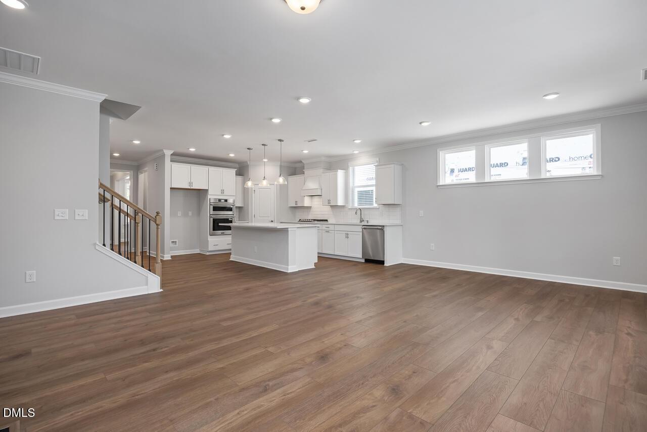 Open-concept kitchen with white cabinets and island in The Ashport L plan at Sage on North Main, Wake Forest, NC.