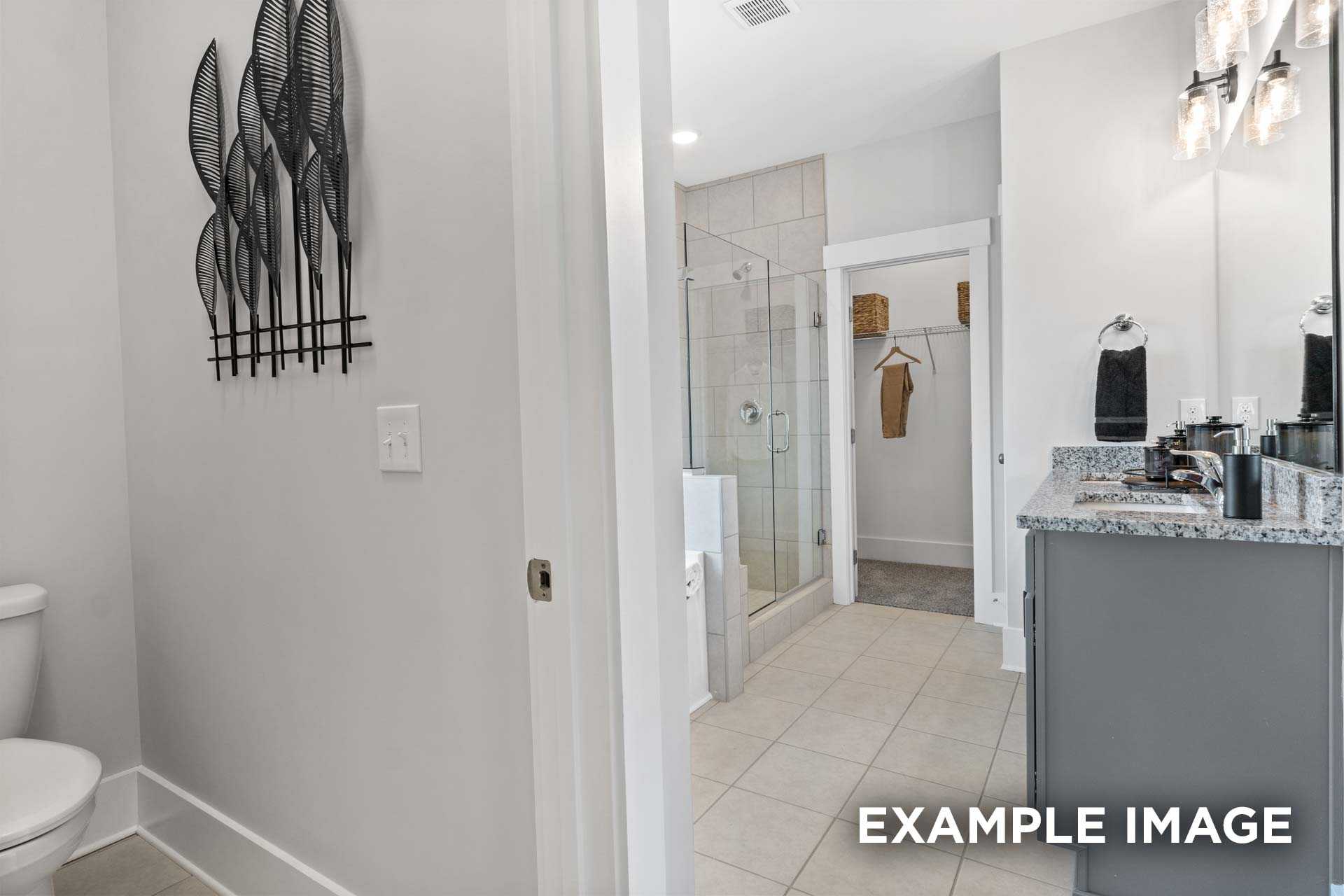 Master bathroom in The Franklin C featuring walk-in shower, quartz vanity, and adjacent closet
