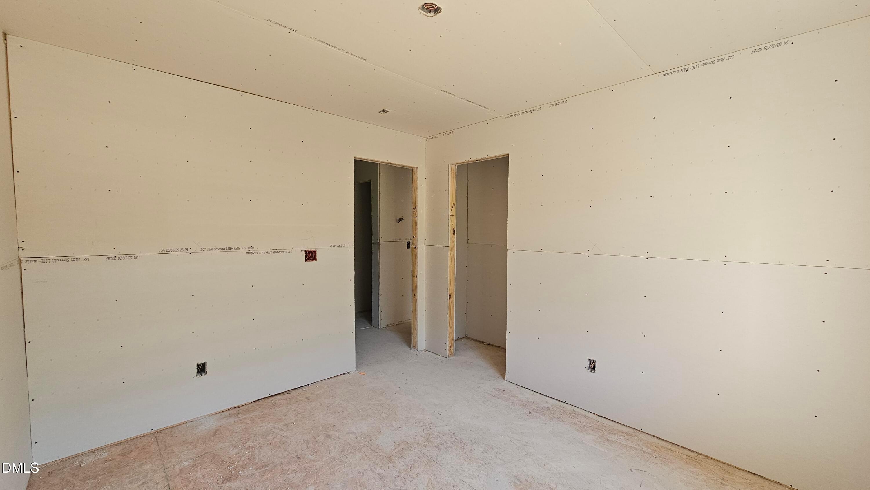 Unfinished bedroom with drywall installation in The Graham floor plan at Springvale, Fuquay-Varina, North Carolina.
