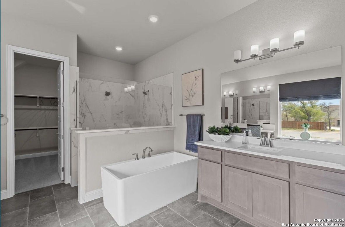 Luxurious master bathroom with freestanding tub, frameless glass shower, double marble vanity in The Garner B, Ladera, San Antonio