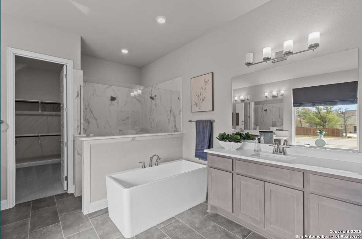 Luxurious master bathroom with freestanding tub, marble shower, double vanity in Davidson Homes The Garner B, Ladera, San Antonio
