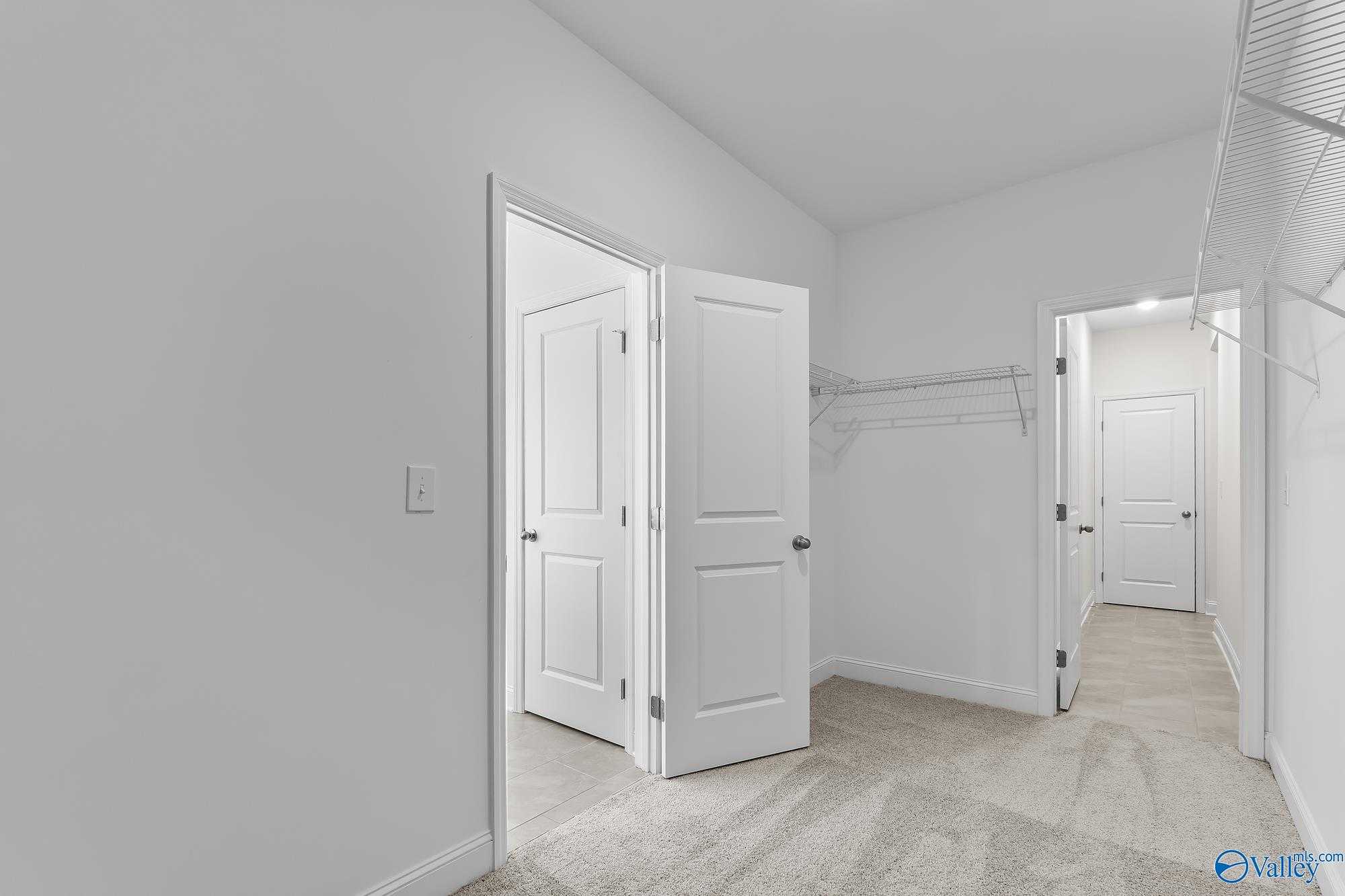 Spacious walk-in closet with wire shelving and open doors in master suite, Davidson Homes The Harrison, Meridianville, Alabama