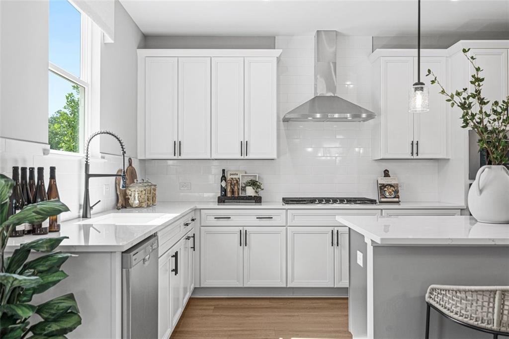 Bright modern kitchen with white cabinets, stainless steel appliances, gray island in Davidson Homes The Hickory B, Hoschton, GA