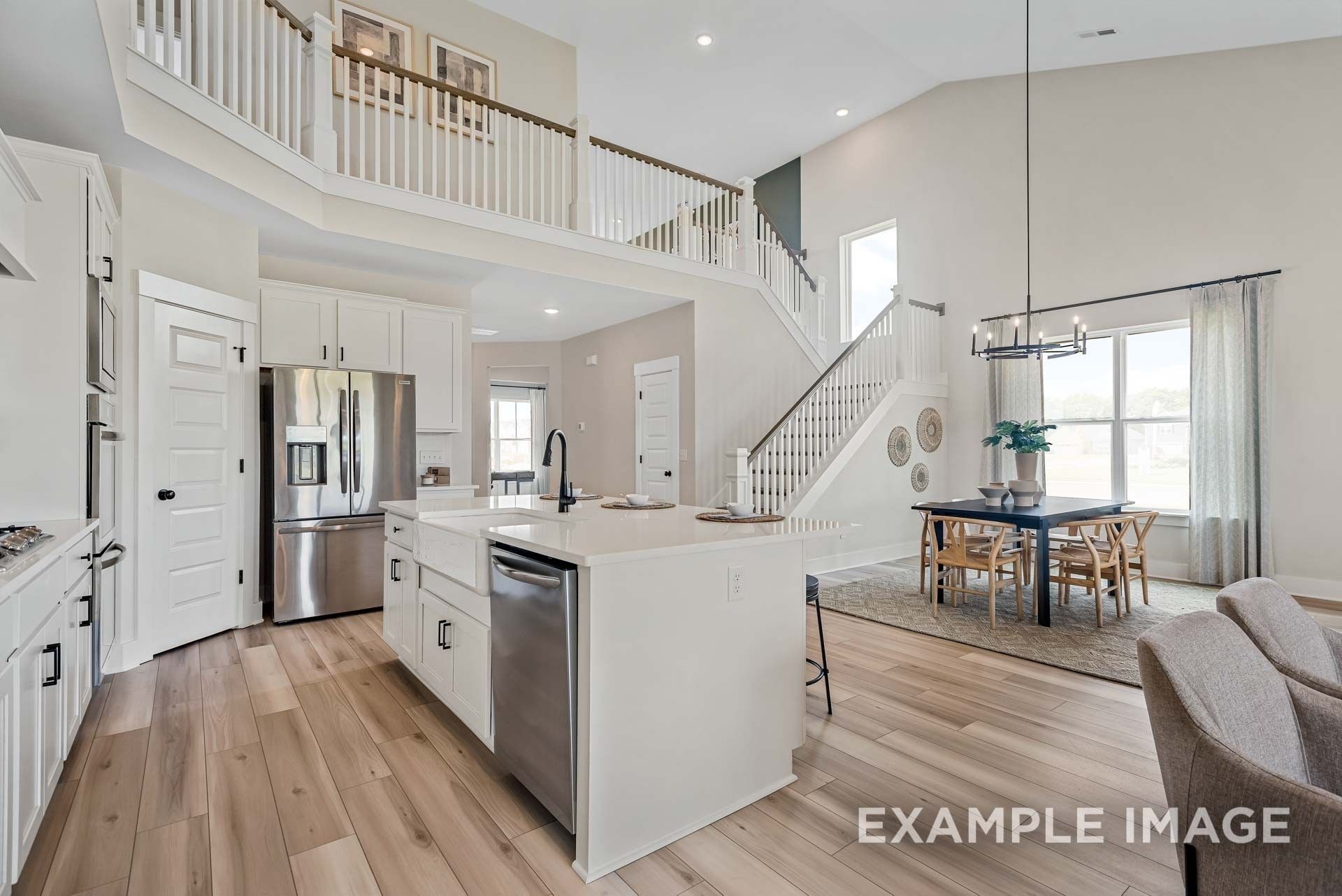 Spacious two-story open kitchen with white cabinets, stainless appliances, island, and dining nook in Davidson Homes Ridgeport C, Gallatin, TN