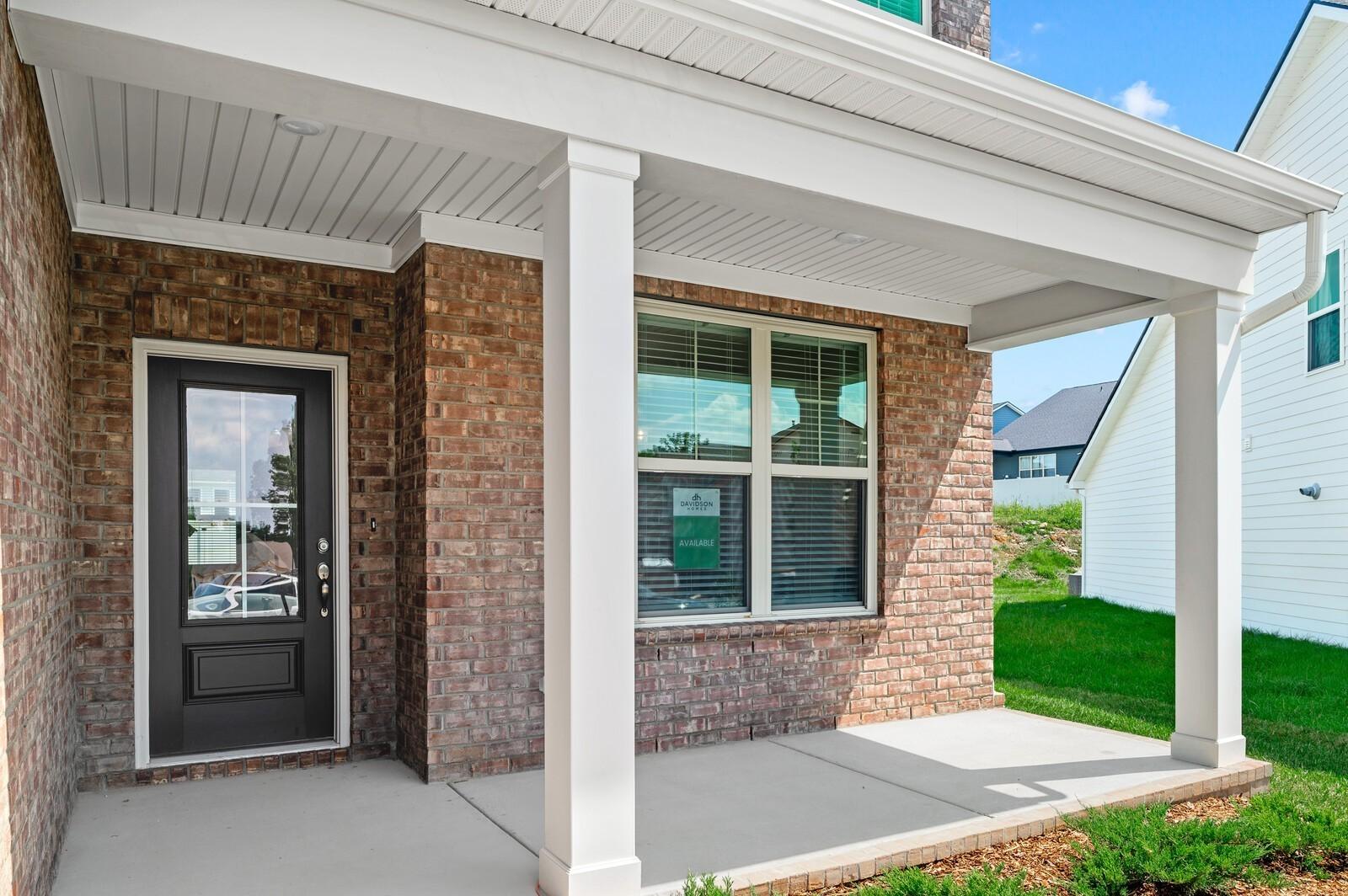 Covered brick front porch of The Ash A floor plan by Davidson Homes in Woods Crossing, Gallatin, Tennessee.
