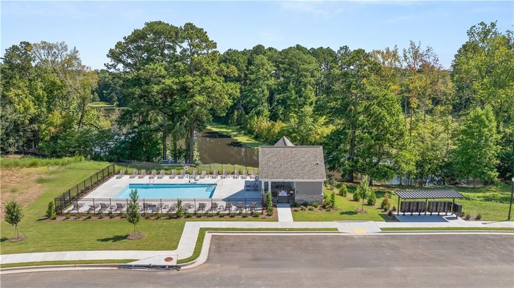 Resort-style community pool and clubhouse overlooking scenic lake at Lake Shore by Davidson Homes in Winder, Georgia