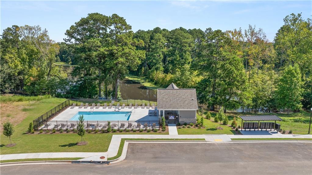 Resort-style community pool and clubhouse overlooking scenic lake at Lake Shore by Davidson Homes in Winder, Georgia