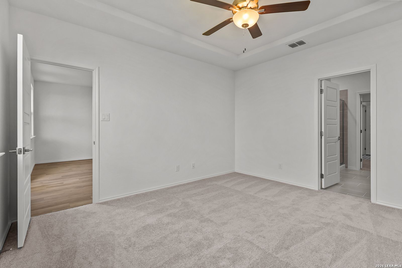 Spacious bedroom with tray ceiling and ceiling fan in The Brazos B floor plan by Davidson Homes in Agave, San Antonio.