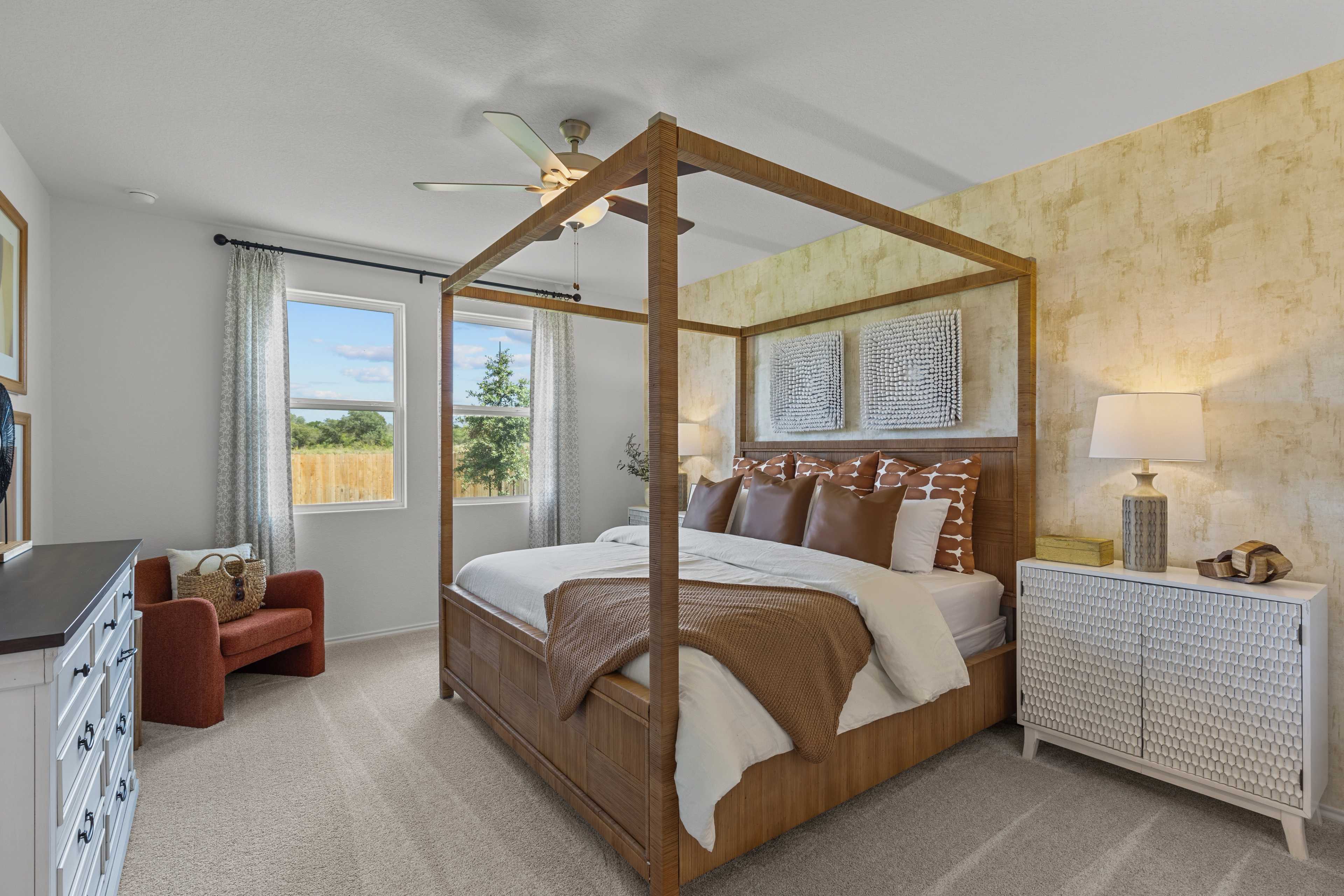 Spacious master bedroom in The Daphne H featuring wooden canopy bed, beige linens, and textured walls