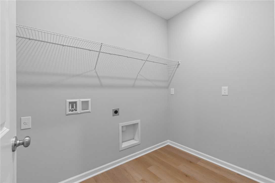 Spacious laundry room with wire shelving, washer-dryer hookups in Davidson Homes The Luna B, Opelika, Alabama