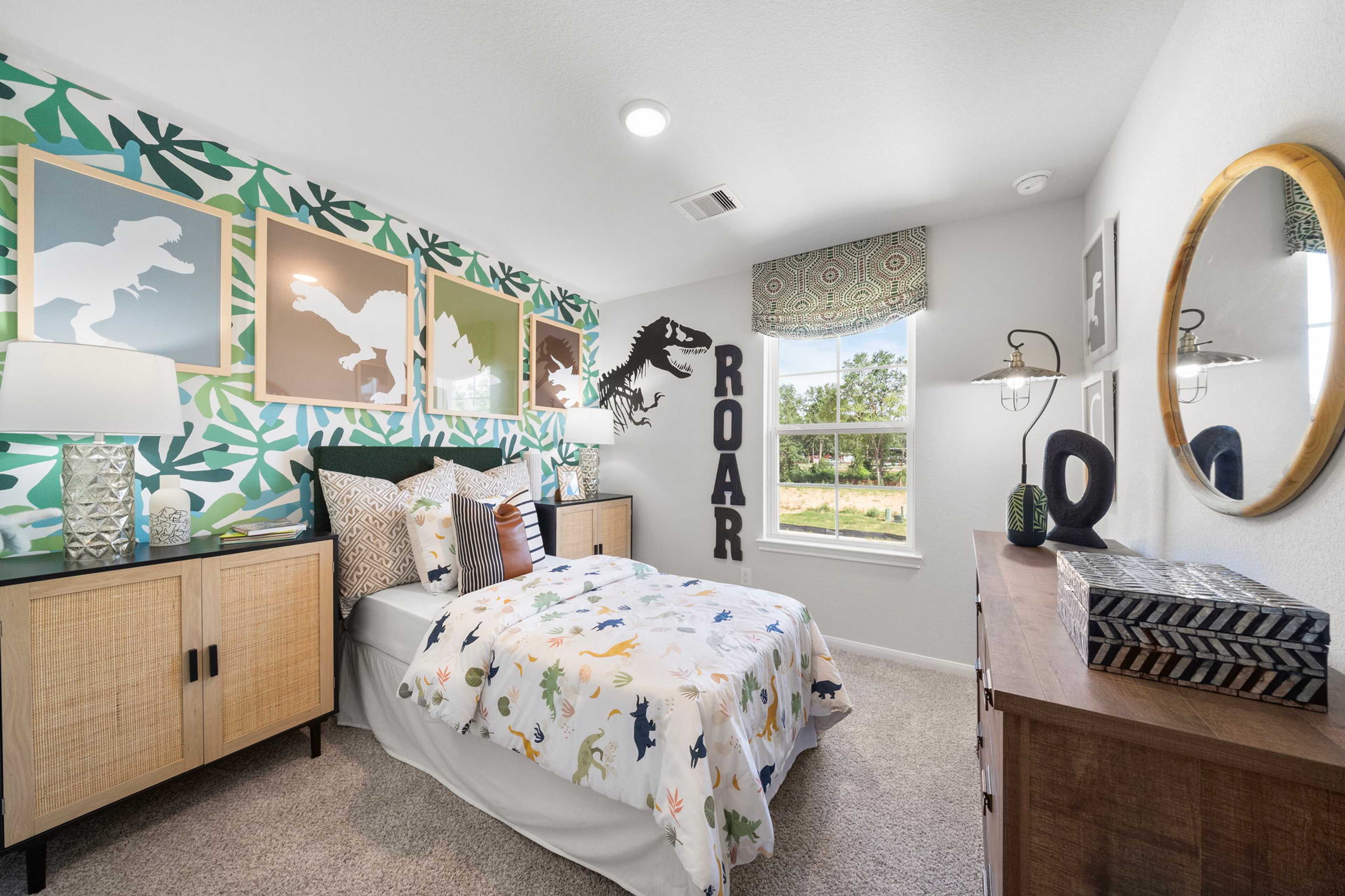 Dinosaur-themed kids bedroom at Caney Creek Place in Conroe TX with leafy green wallpaper, twin bed and ROAR wall sign