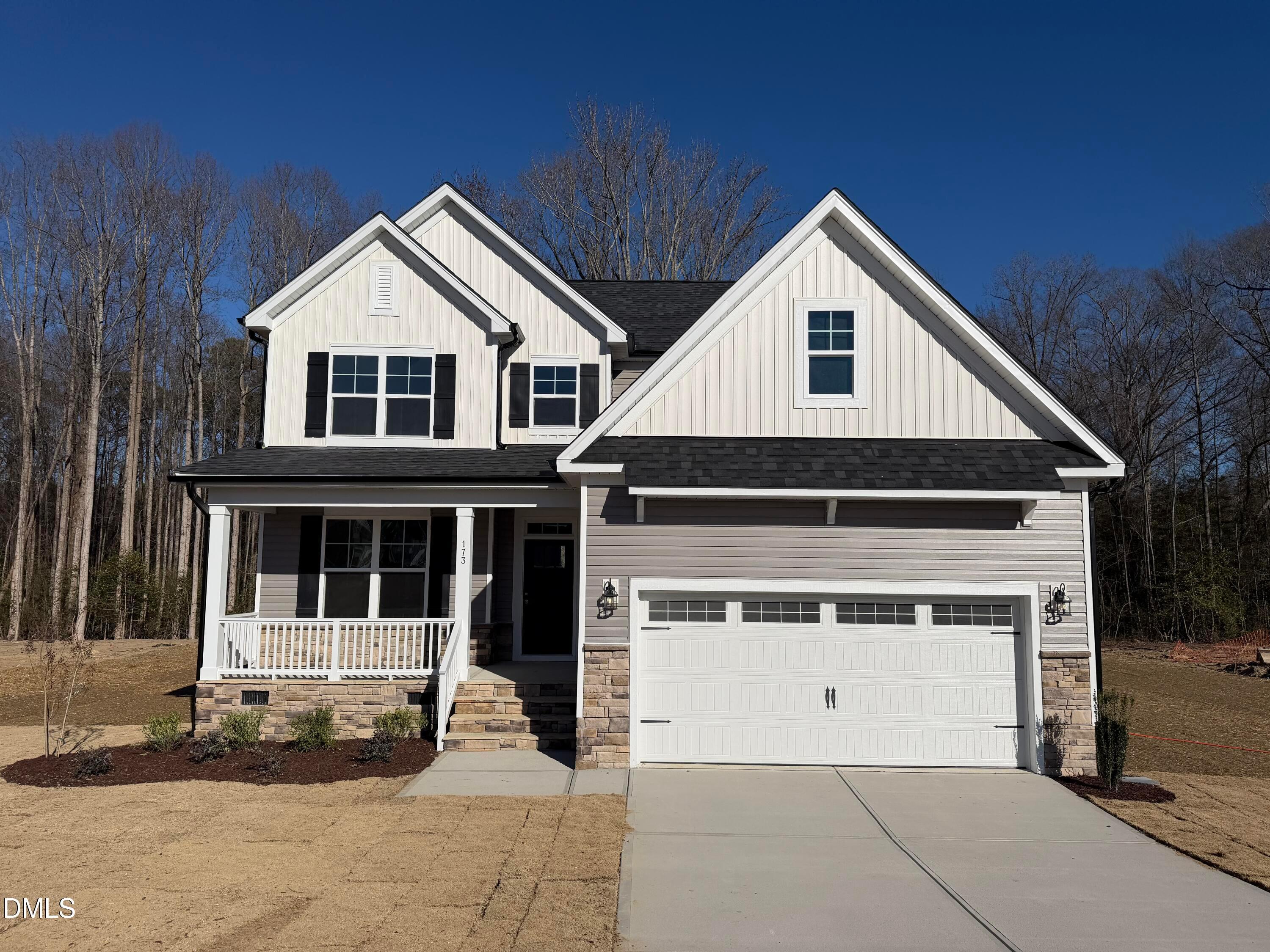 Two-story Davidson Homes The Ash B with white siding, covered front porch, and two-car garage in Wellers Knoll, Lillington, NC