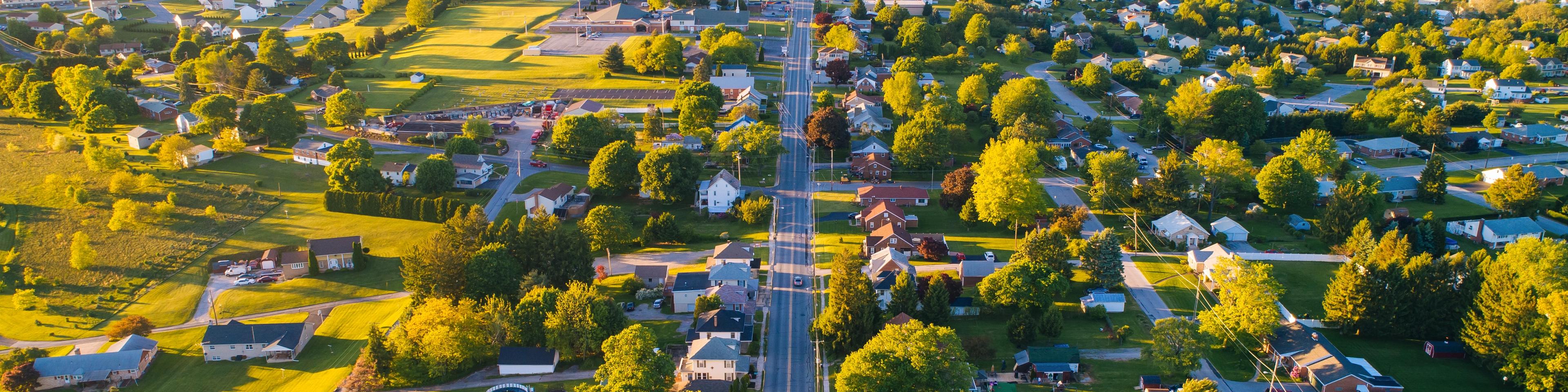 Aerial view of Mooresville Station neighborhood in Tanner Alabama with tree-lined streets homes and green fields