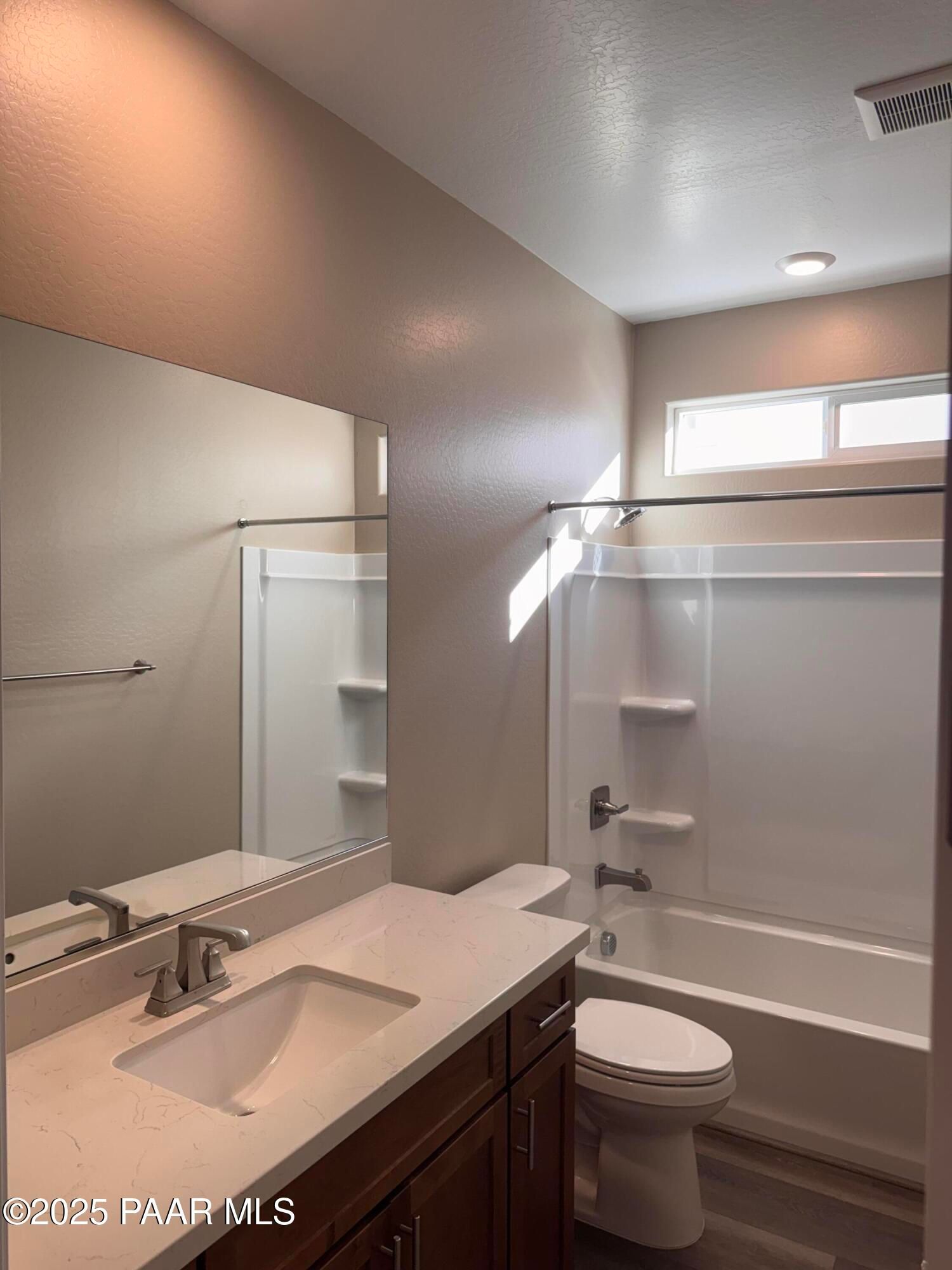 Modern bathroom featuring quartz vanity, tub-shower combo, and wood-look flooring in Davidson Homes The Sunrise II A, Prescott, AZ