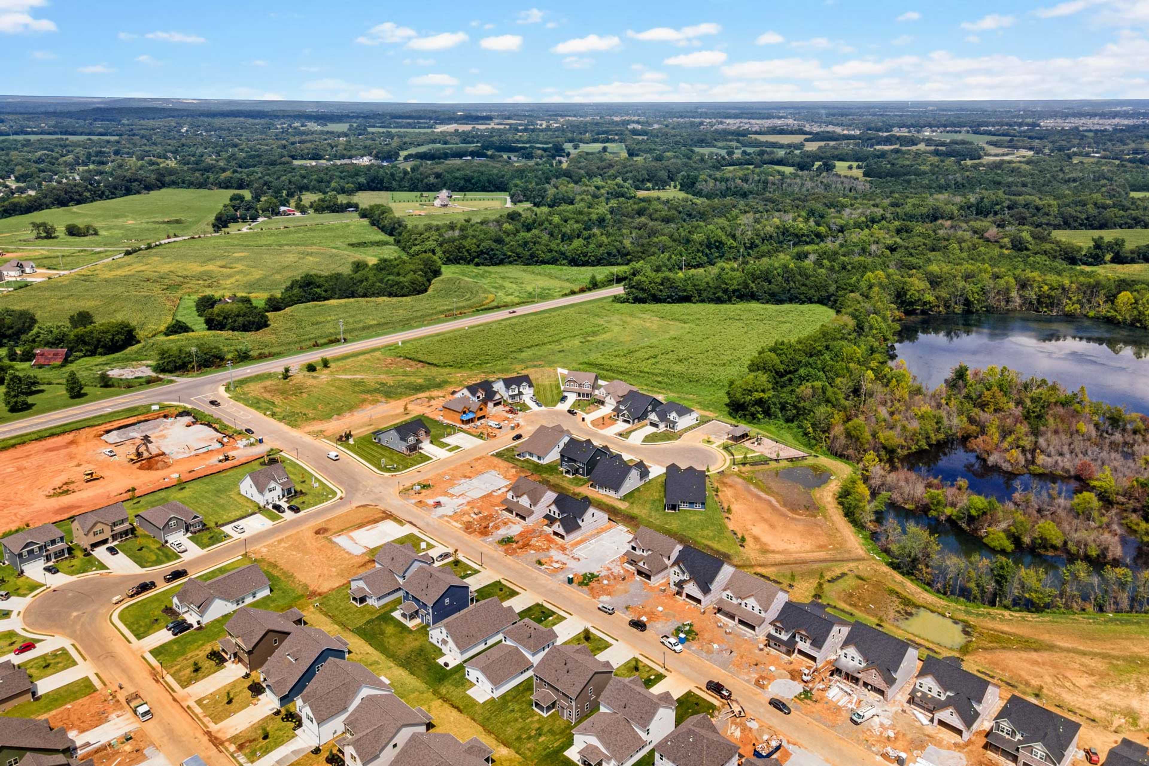 Aerial view of Salem Landing new homes in Murfreesboro Tennessee by Davidson Homes amid green fields, woods, and pond