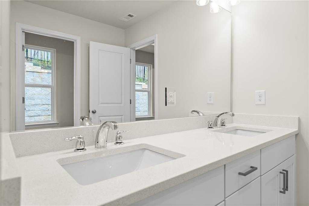 Modern master bathroom double vanity with white quartz counters, mirrors, and chrome faucets in Davidson Homes The Marion B, Kennesaw, GA