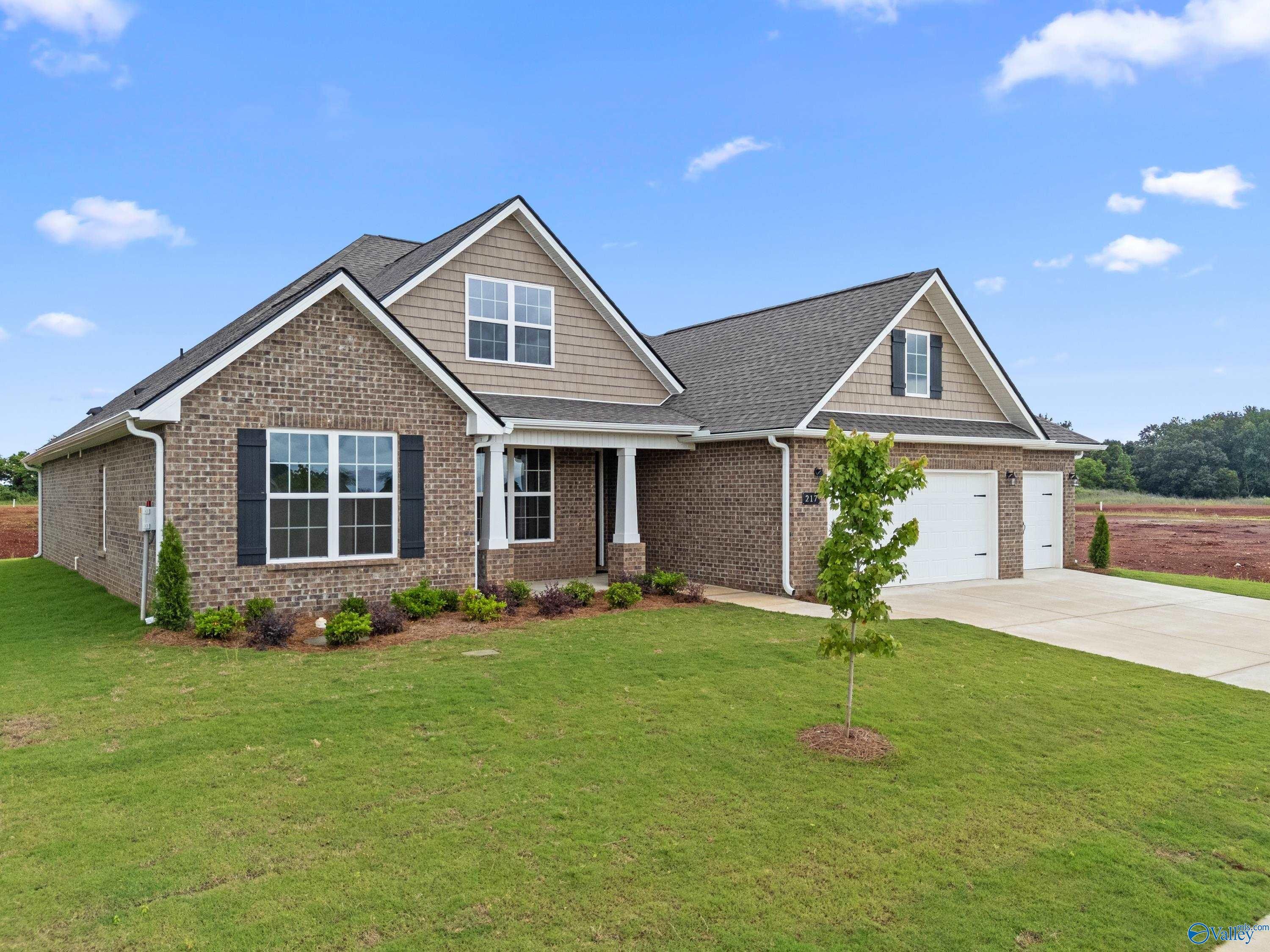 Brick and siding 1-story home with 3-car garage, front porch, and landscaped yard in Kendall Farms, Toney, Alabama by Davidson Homes