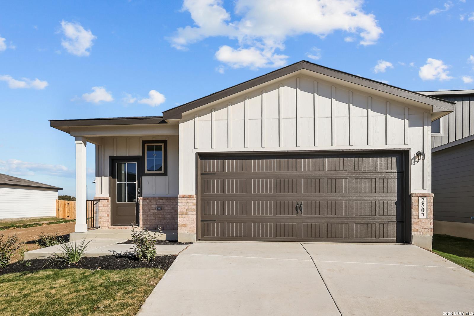 Modern single-story 3-bed home exterior with 2-car garage, covered porch, and brick accents in Applewhite Meadows, San Antonio