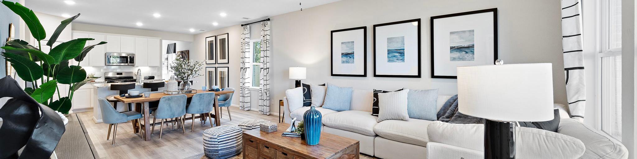 Open-concept living and dining room at Lakes at Black Oak in Magnolia Texas with hardwood floors, white sofa, and ceiling fans