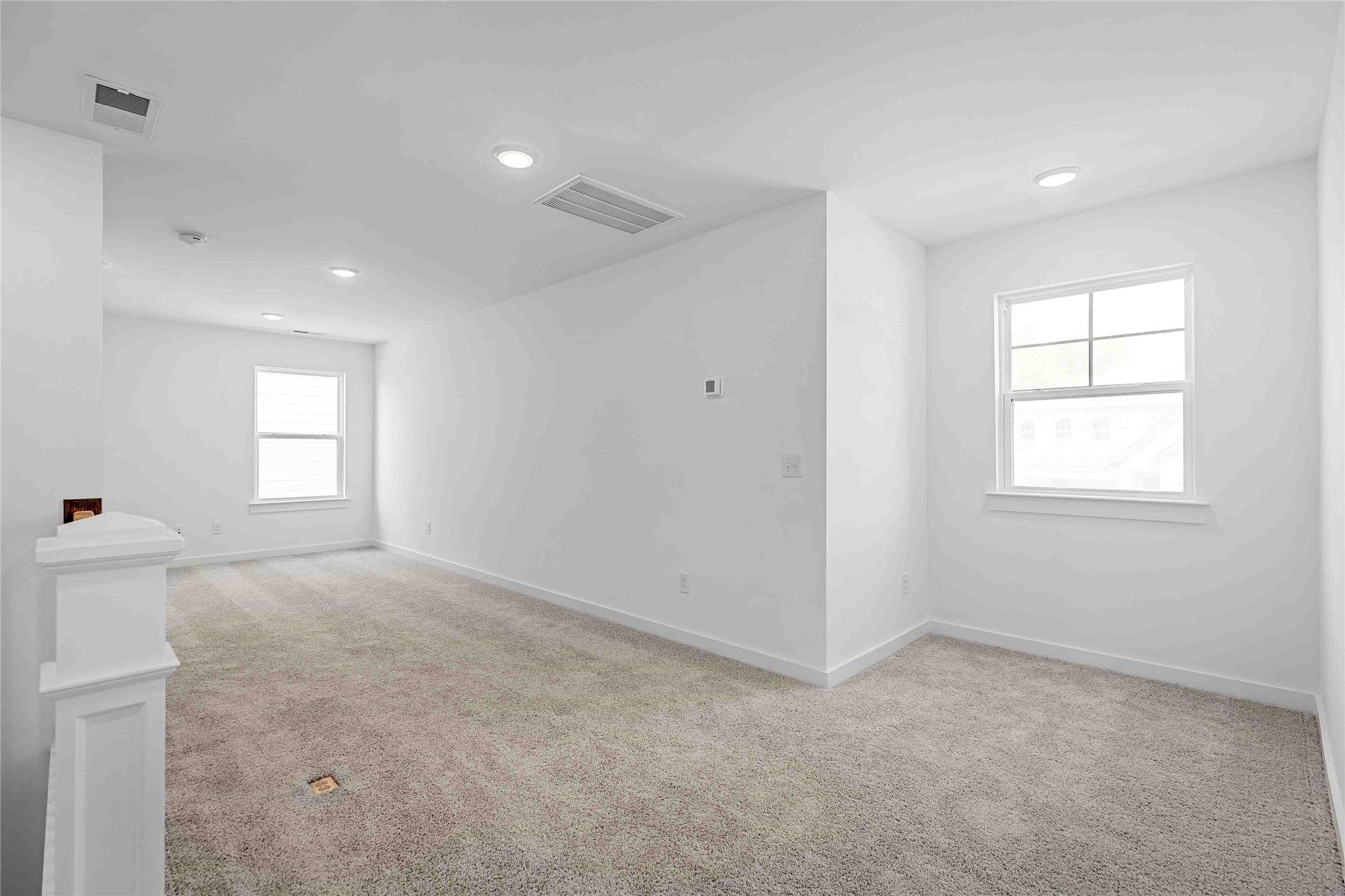 Spacious second-floor game room with carpet and recessed lighting in Davidson Homes The Ash O floor plan, Heartland, TX.