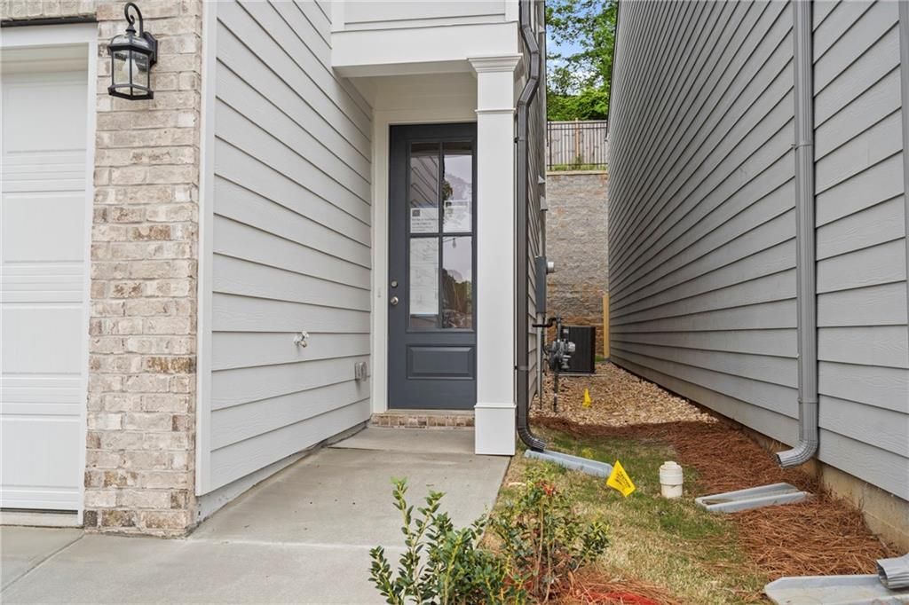 Modern two-story home exterior with two-car garage, shake siding, brick accents, and landscaped entry in The Village at Shallowford, Kennesaw, Georgia