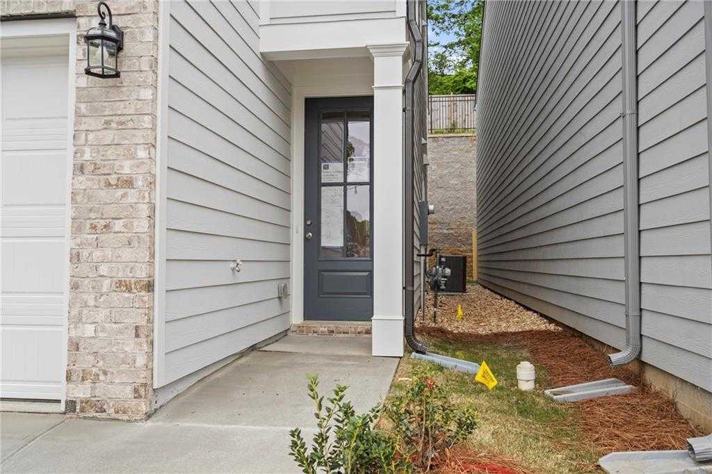 Modern two-car garage with white door and gray glass-paneled entry on brick-accented siding home in The Village at Shallowford, Kennesaw, Georgia
